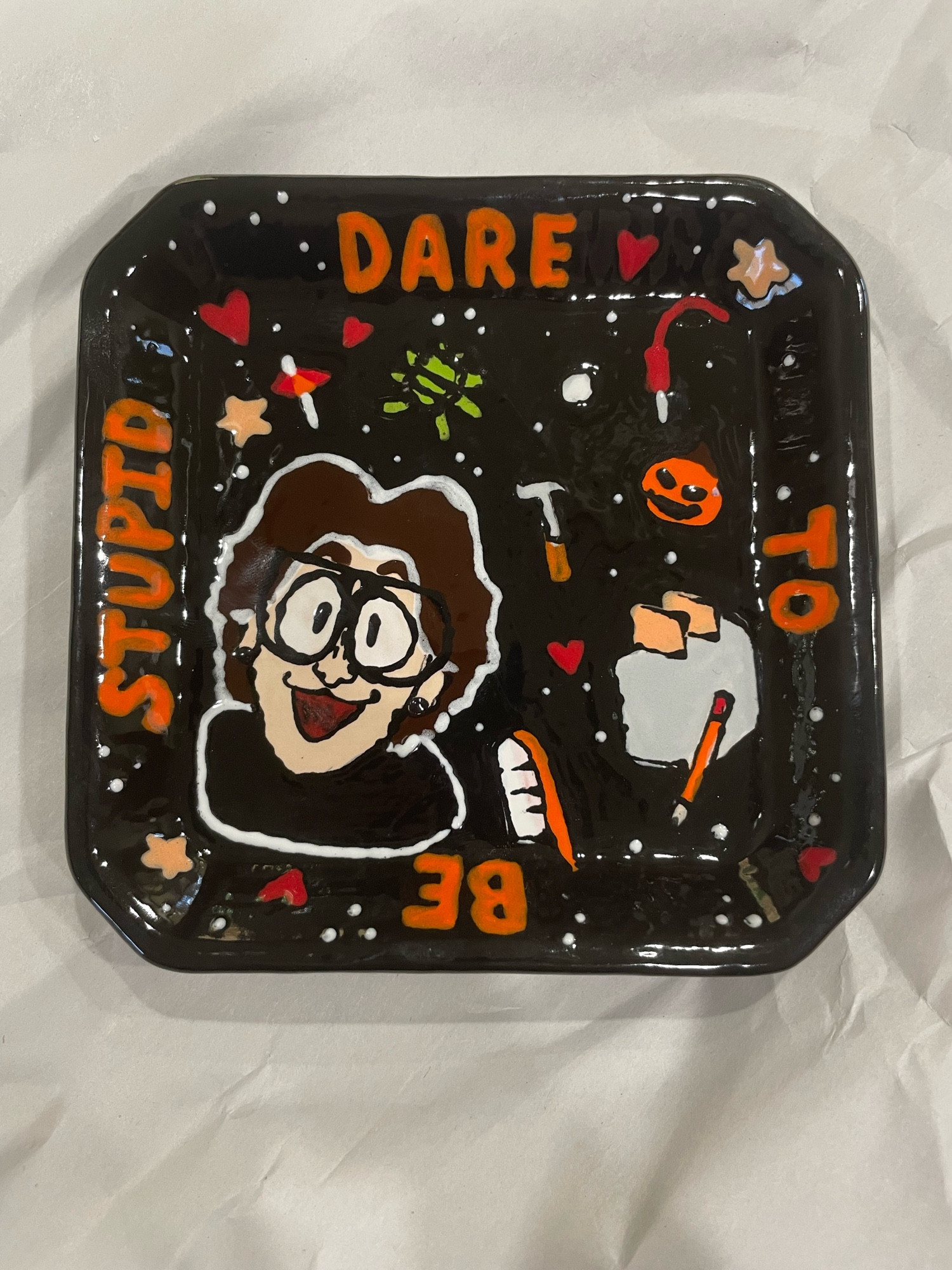 A small dish from a pottery painting place that is a self portrait of me on the cover of Weird Al’s “Dare to be Stupid” album!