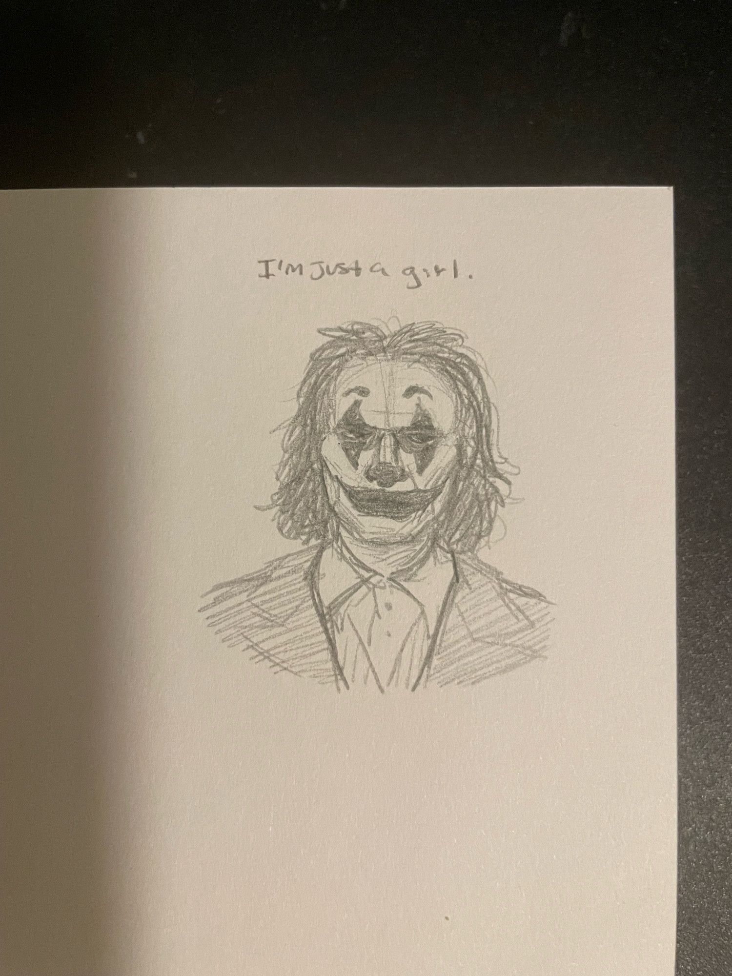 A headshot of the Joker (2019) with the caption “I’m just a girl”