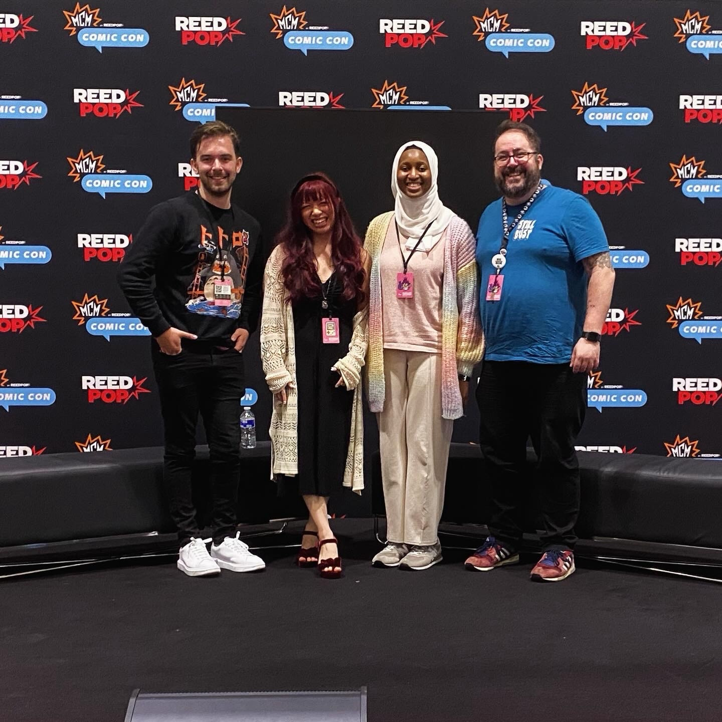 Shaun Mendum, Amina Koroma, Leader Looi and JD Kelly stand on stage at Comic Con after doing a panel on Voice Acting