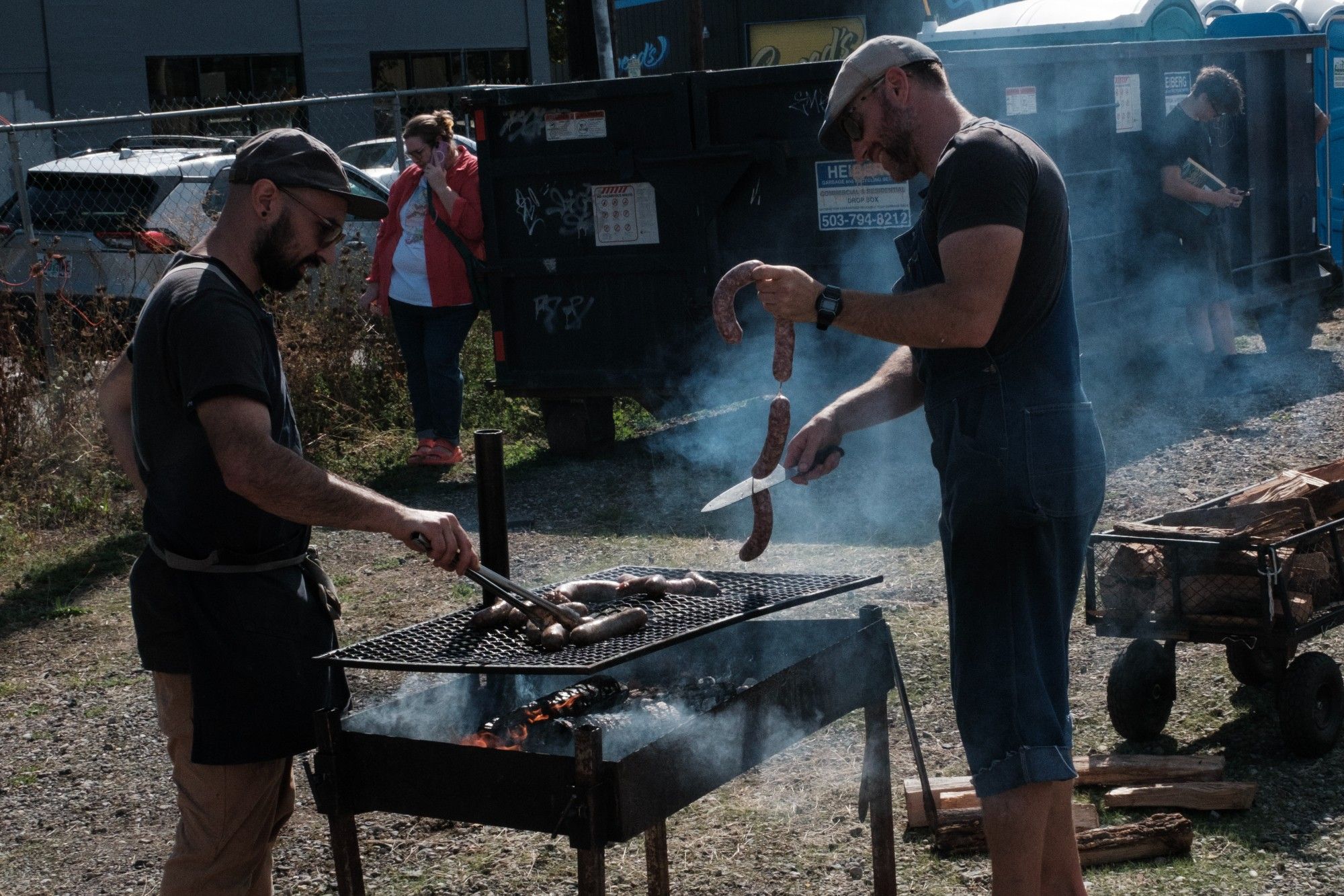 Two men at the Proletariat Butchery grillin' sausages.