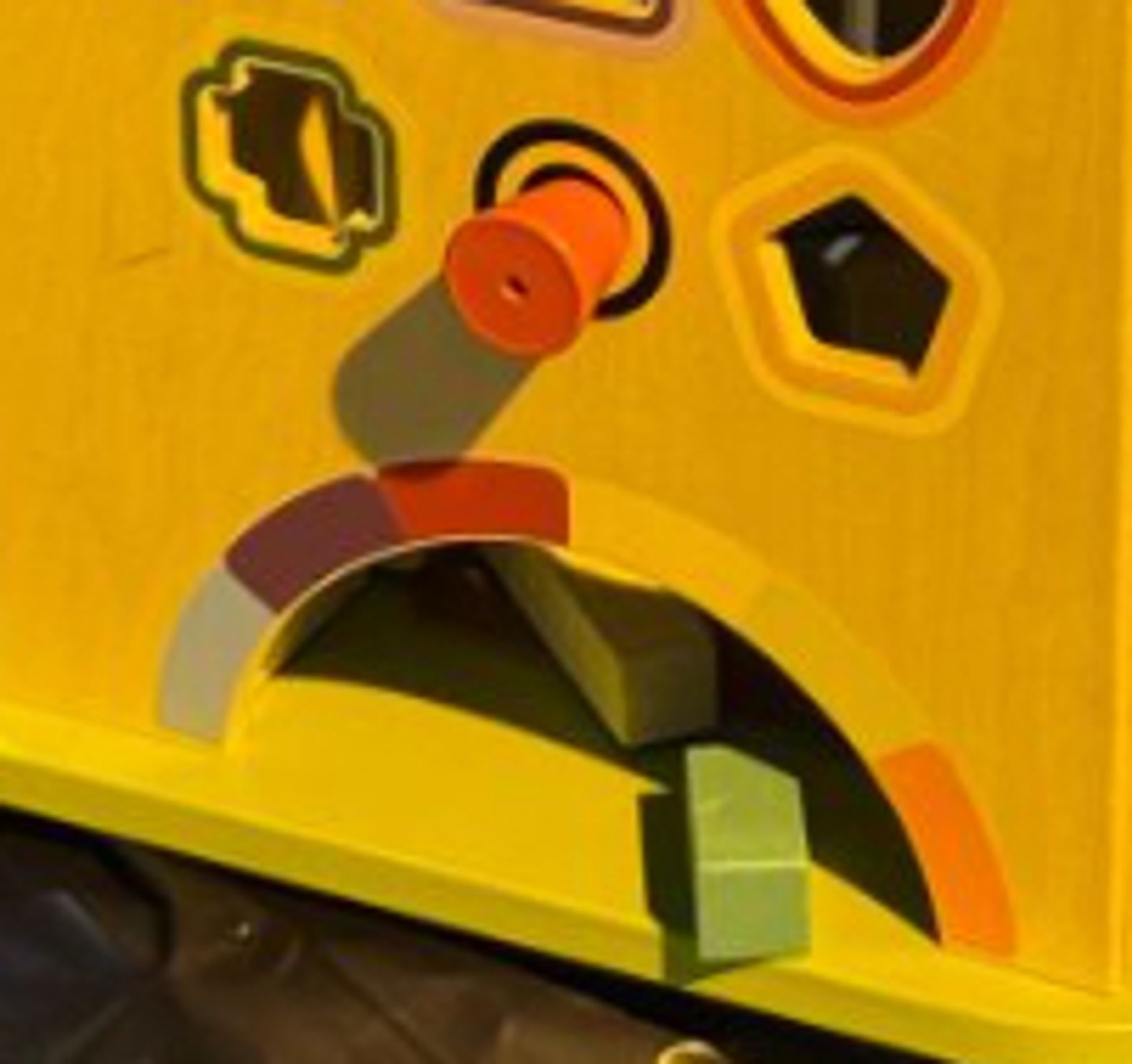 Cropped section of the photo that makes it look like the toddler activity cube is vomiting green bricks and is sad about it