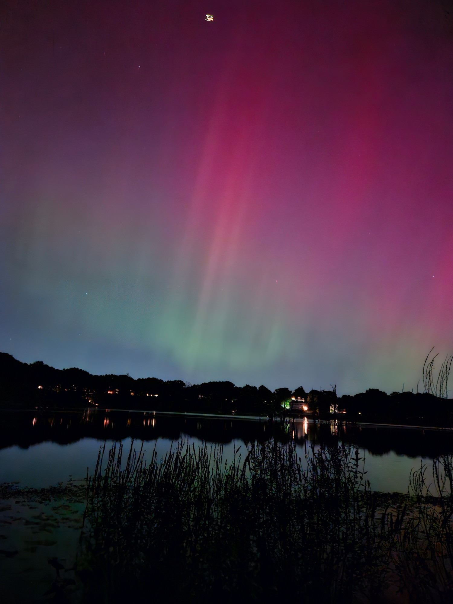 Vertical image shows jets streaking through pink and green patches of sky