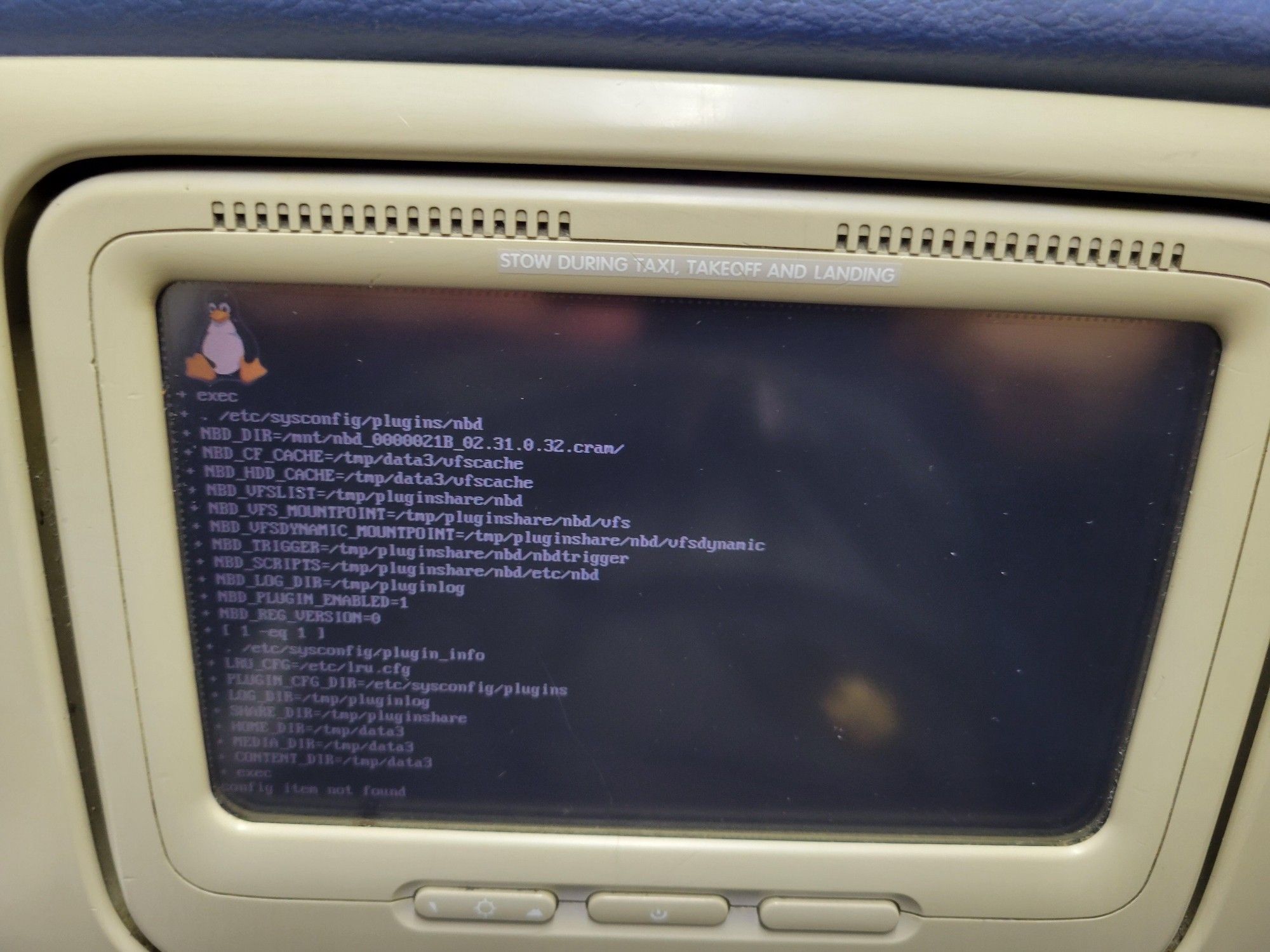 Linux logo and console code scrolling by on plane seat back monitor