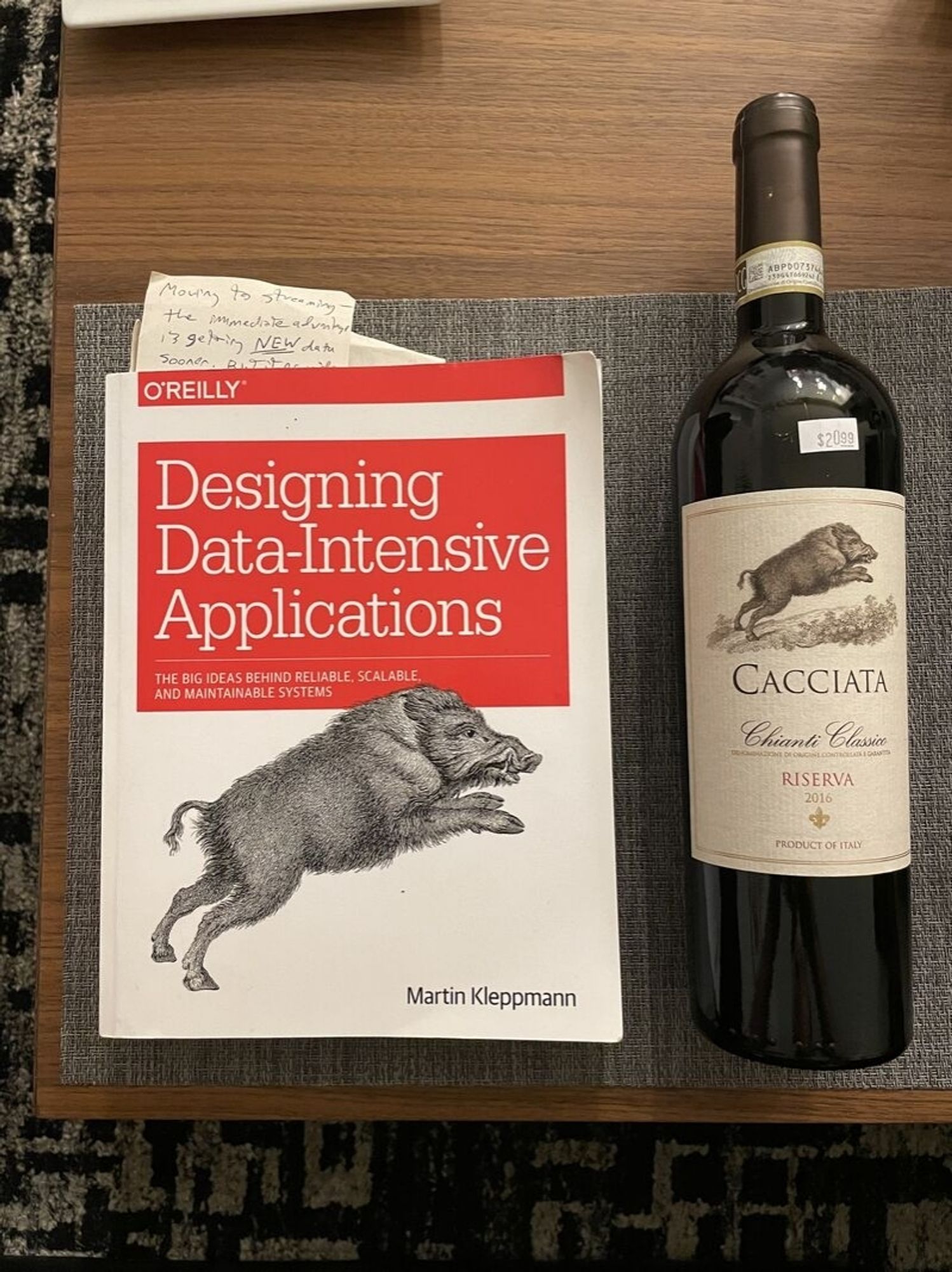 Oreilly designing data intensive applications book with a picture of a boar on it, and a bottle of wine with exactly the same illustration