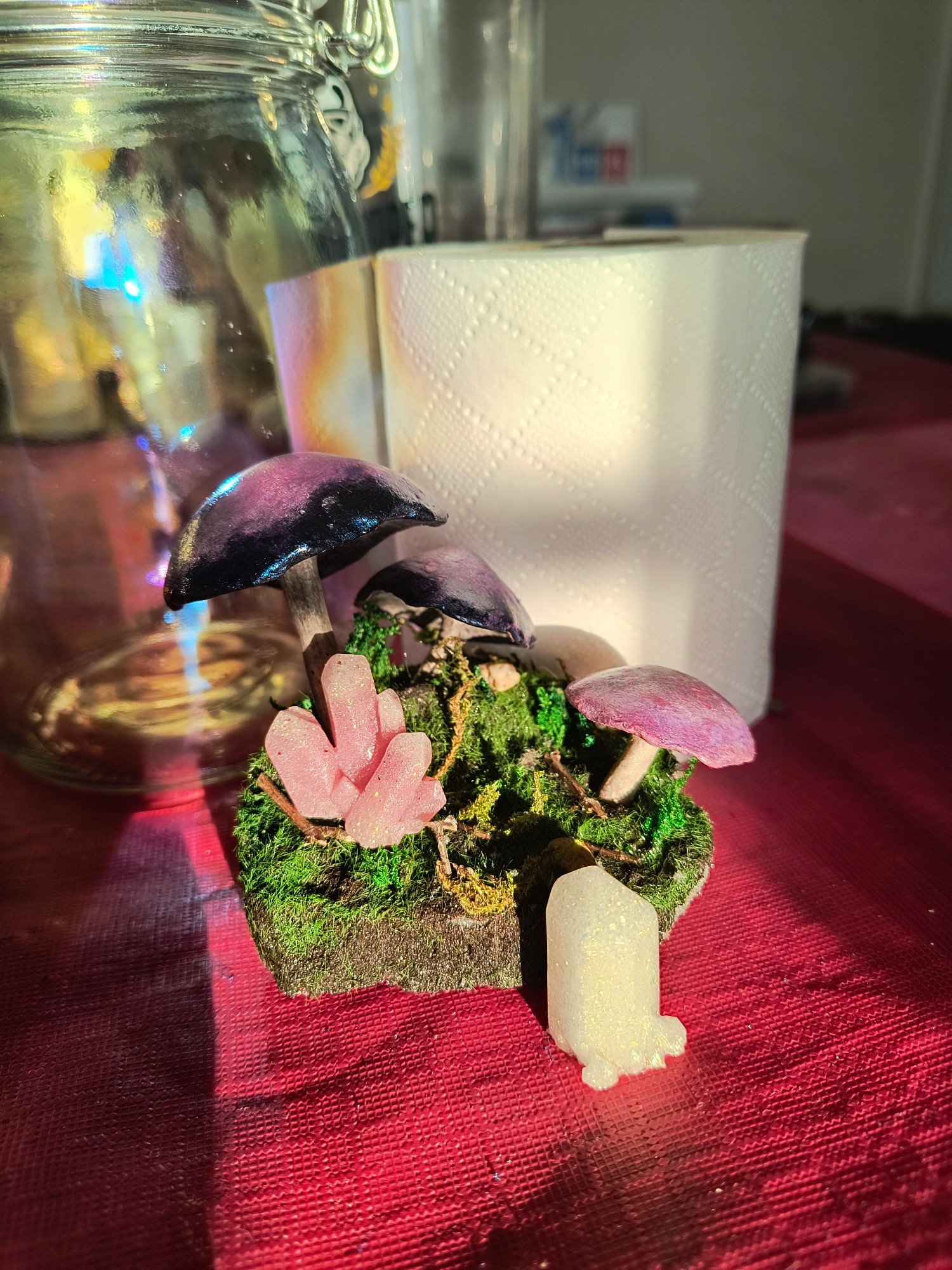 Work in progress picture of a faux miniature mushroom and crystal diorama propped up Infront of an iridescent mason jar, work by SazDz Art.