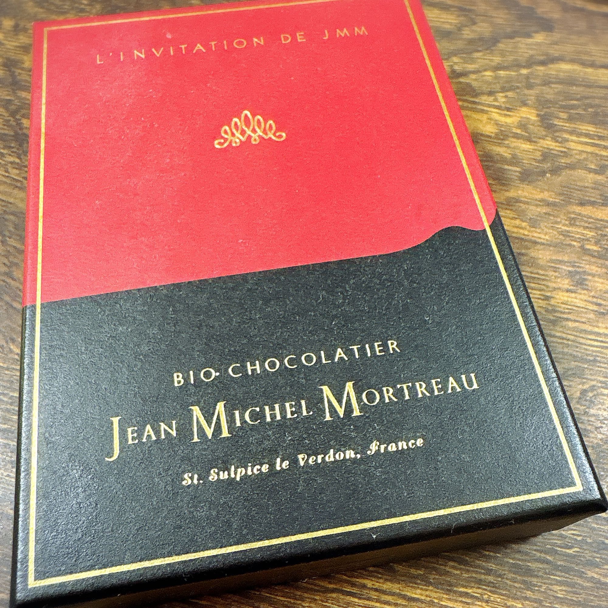 箱の上半分が赤、下半分が黒で、金色の文字が描かれている。ジャン＝ミッシェル・モルトローのオーガニックチョコレートの箱。