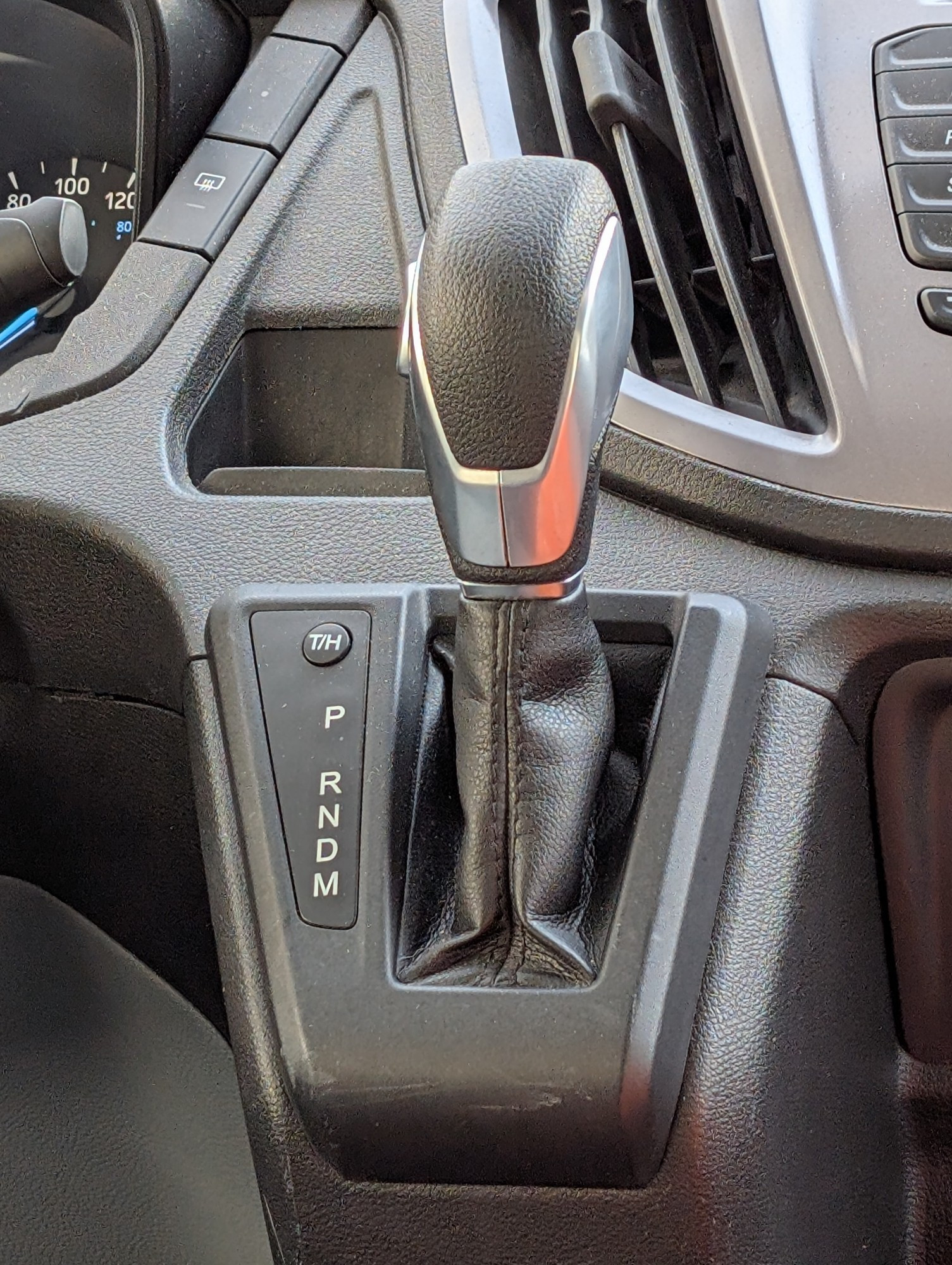 A vehicle shift lever labeled P-R-N-D-M