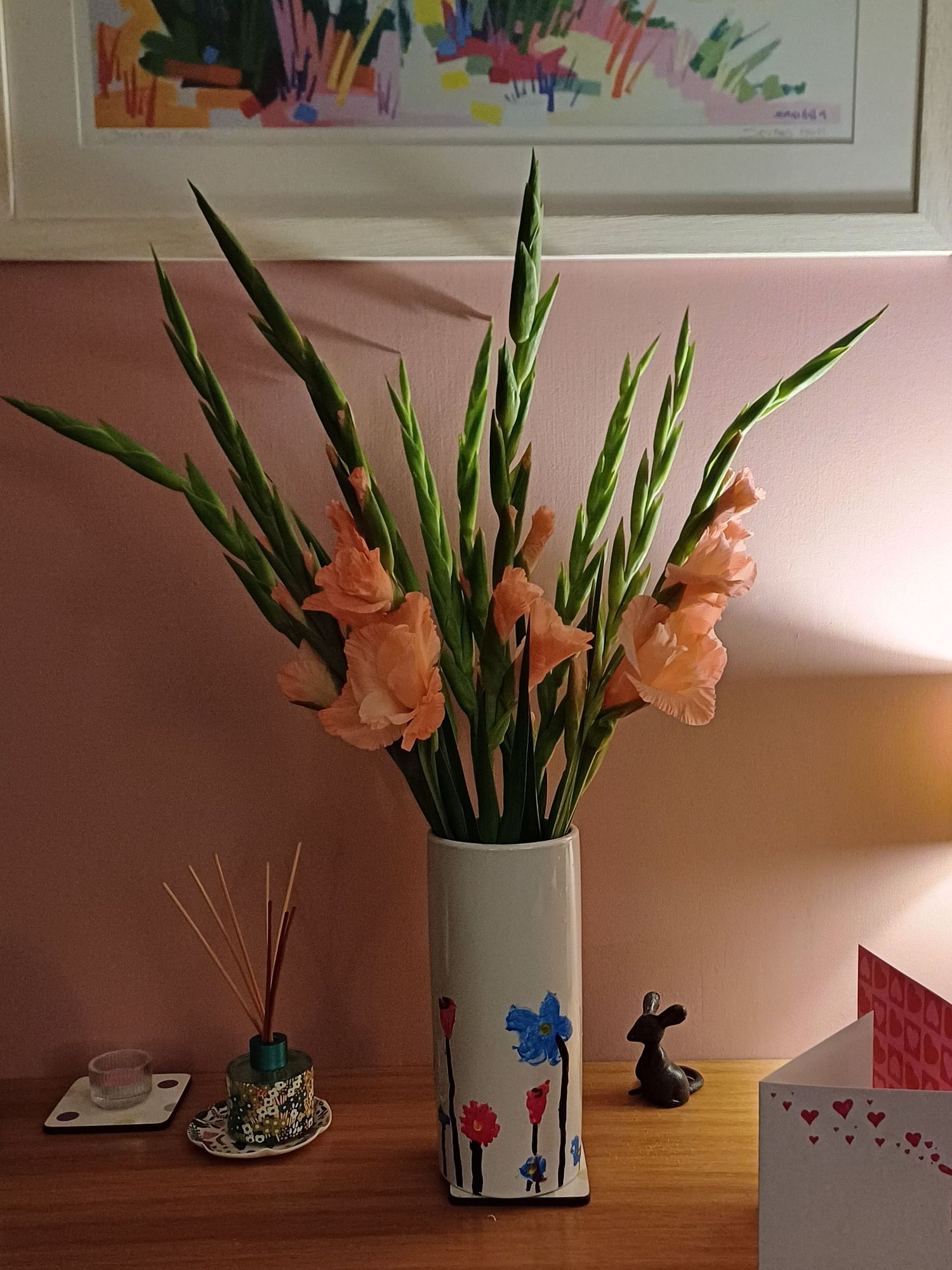 A vase (decorated by kids years ago) with some lovely pink gladioli