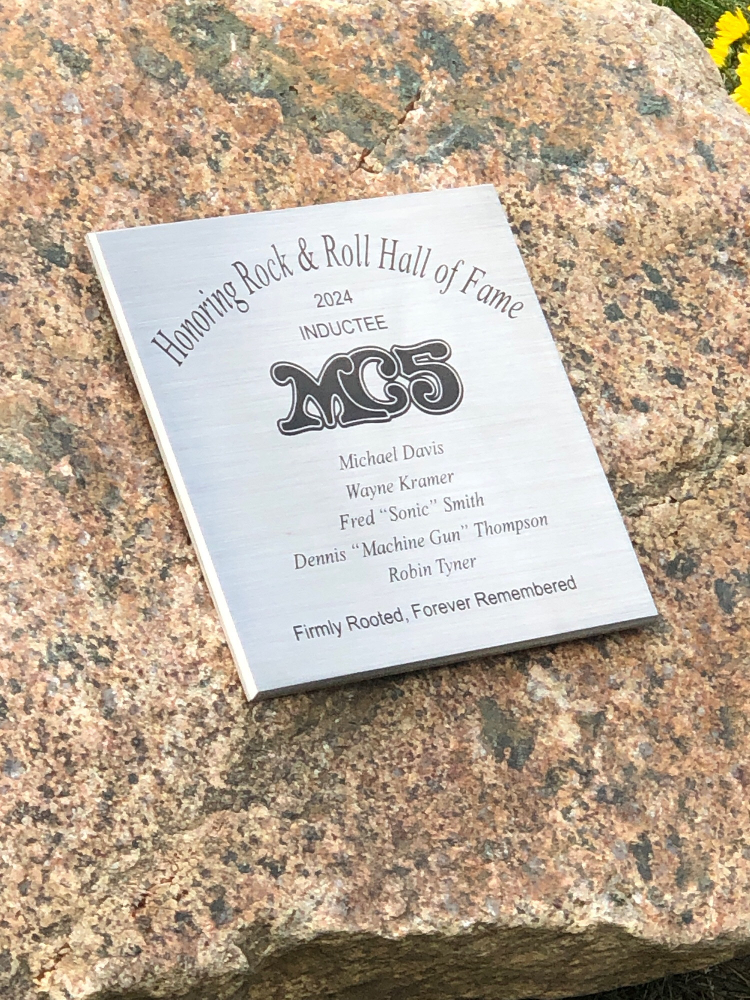 A plaque reading 
HONORING ROCK AND ROLL HALL OF FAME 
2024 INDUCTEES 
MC5
names of the band members 
FIRLY ROOTED, FOREVER REMEMBERED