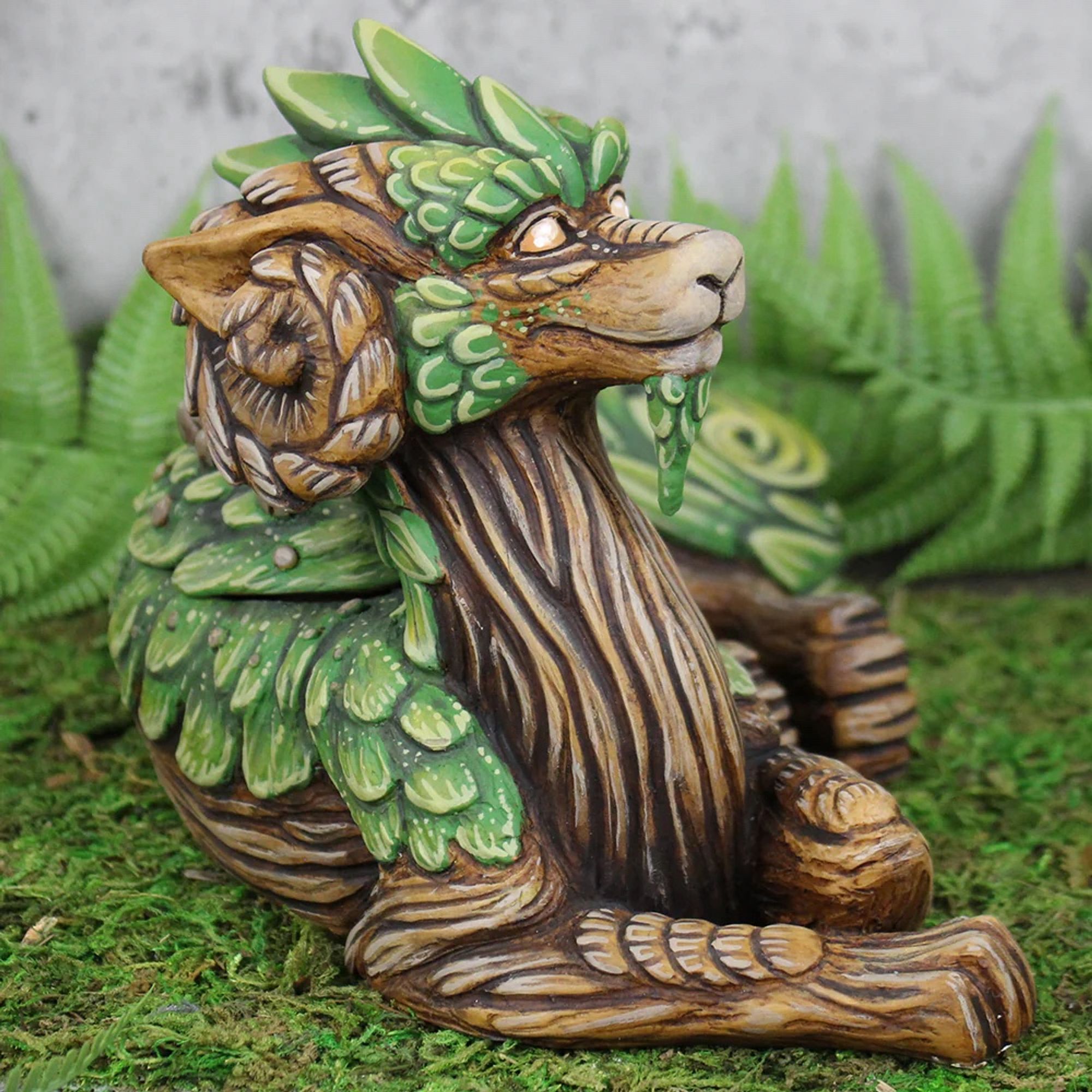 A side view of the mossy tree themed dragon sculpture.