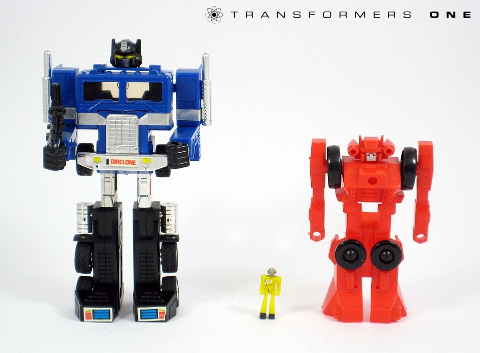 Powered Convoy (Optimus Prime but blue with black and silver accents), a tiny dianaut driver figure, and a red robot who turns into a little cart.