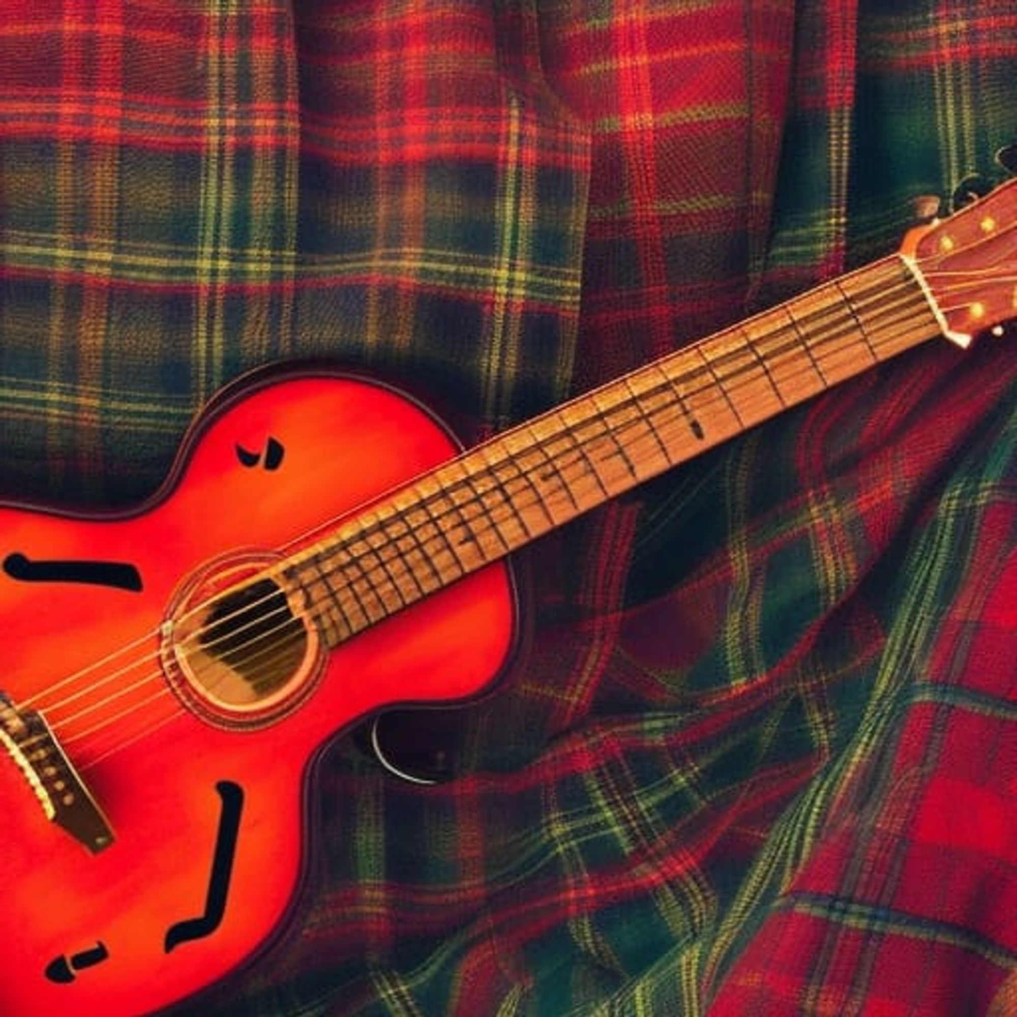 Acoustic guitar on red/green tartan