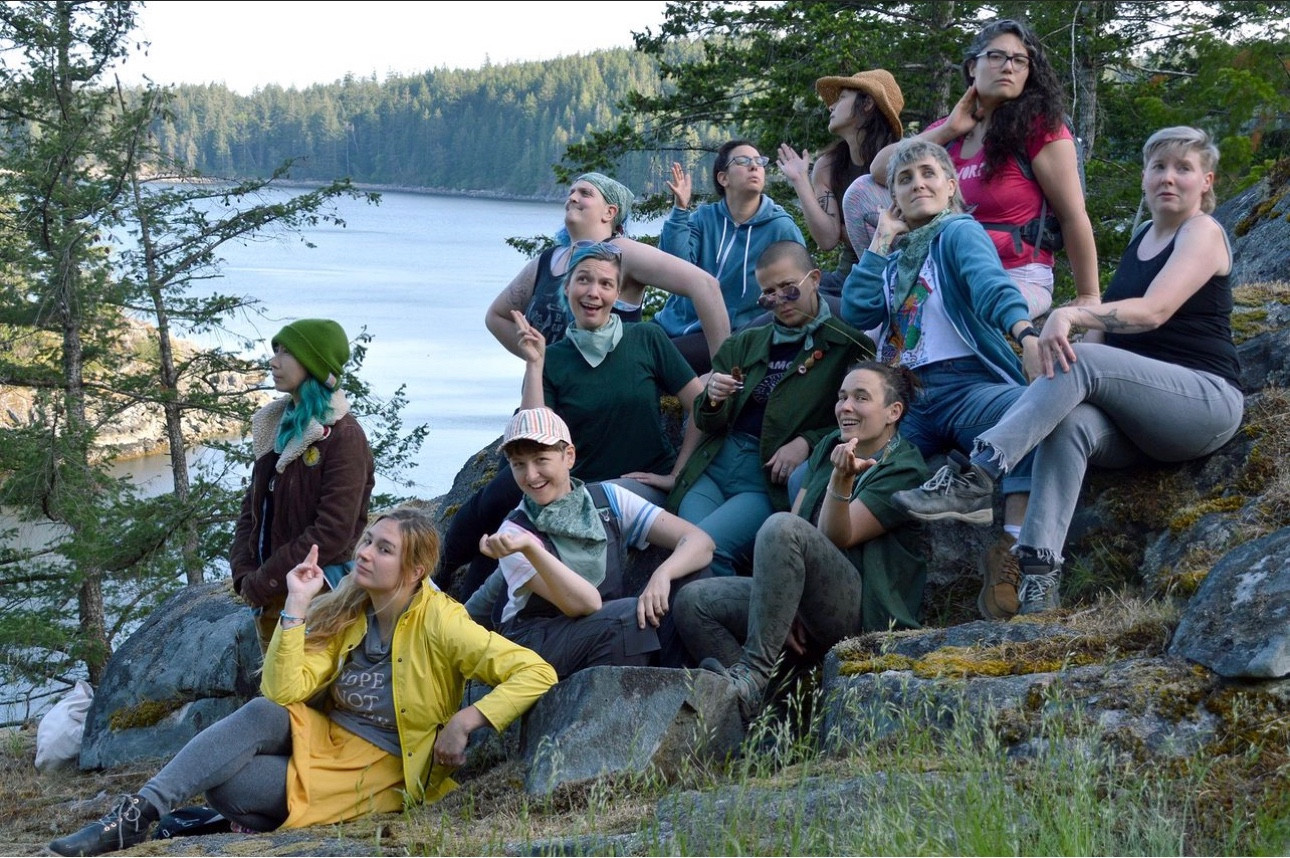 A group photos of retreaters on a rocky cliff area, posing to a prompt along the lines of  “be a Mid-Atlantic socialite from the 1920’s”