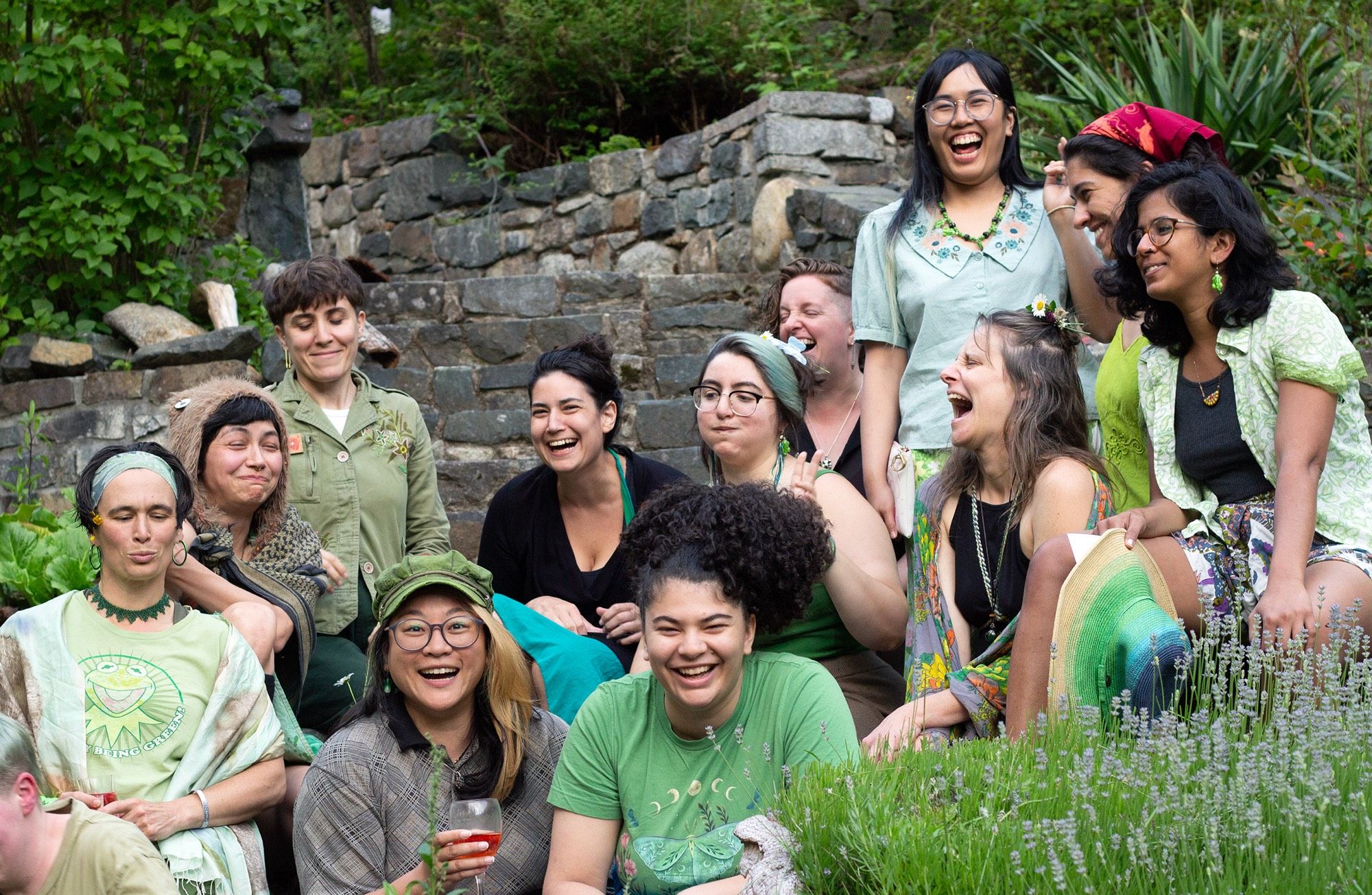 A group of artists sitting on stone steps, many caught mid-laugh or making faces reminiscent of a frog