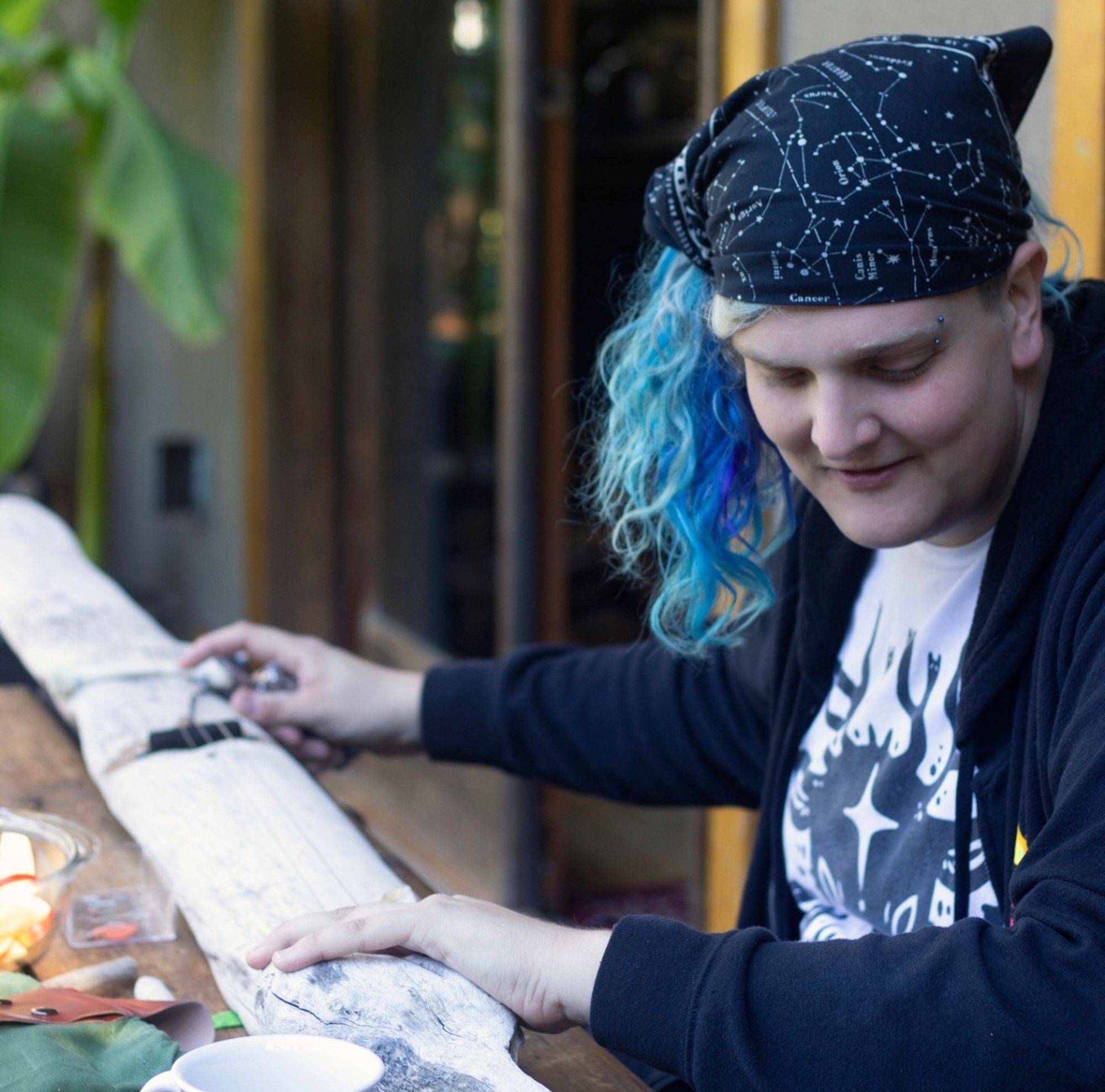 A retreater works to perfect the guitar that she made out of driftwood that she found on a nearby beach. Seriously.