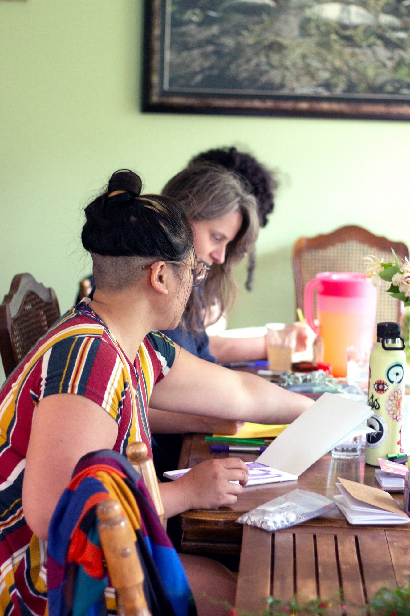 Artists at a table each work on their various projects