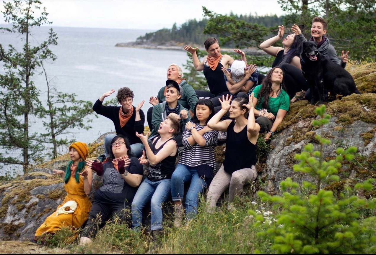 A group photo of retreaters by a scenic overlook, posing to a prompt along the lines of “be your inner animal”