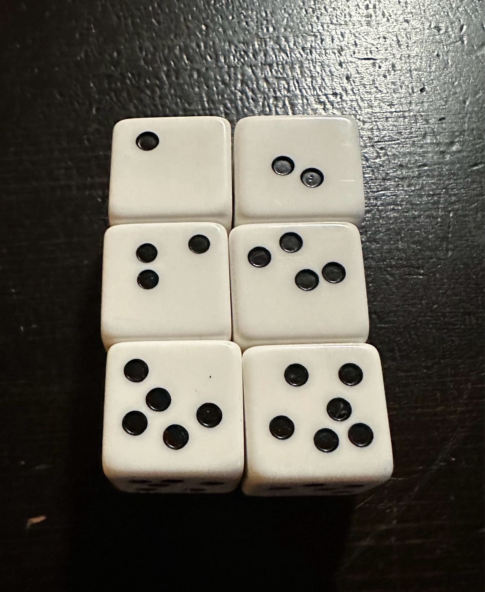 Six white dice with black pips dice labeled 1 through 6 but the pips are not in the standard configuration at all