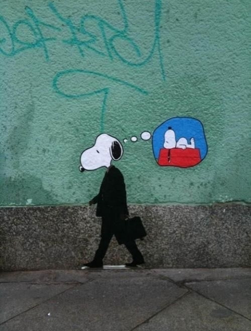 Snoopy est en costume, dans la rue. Il s'imagine endormi sur sa niche.