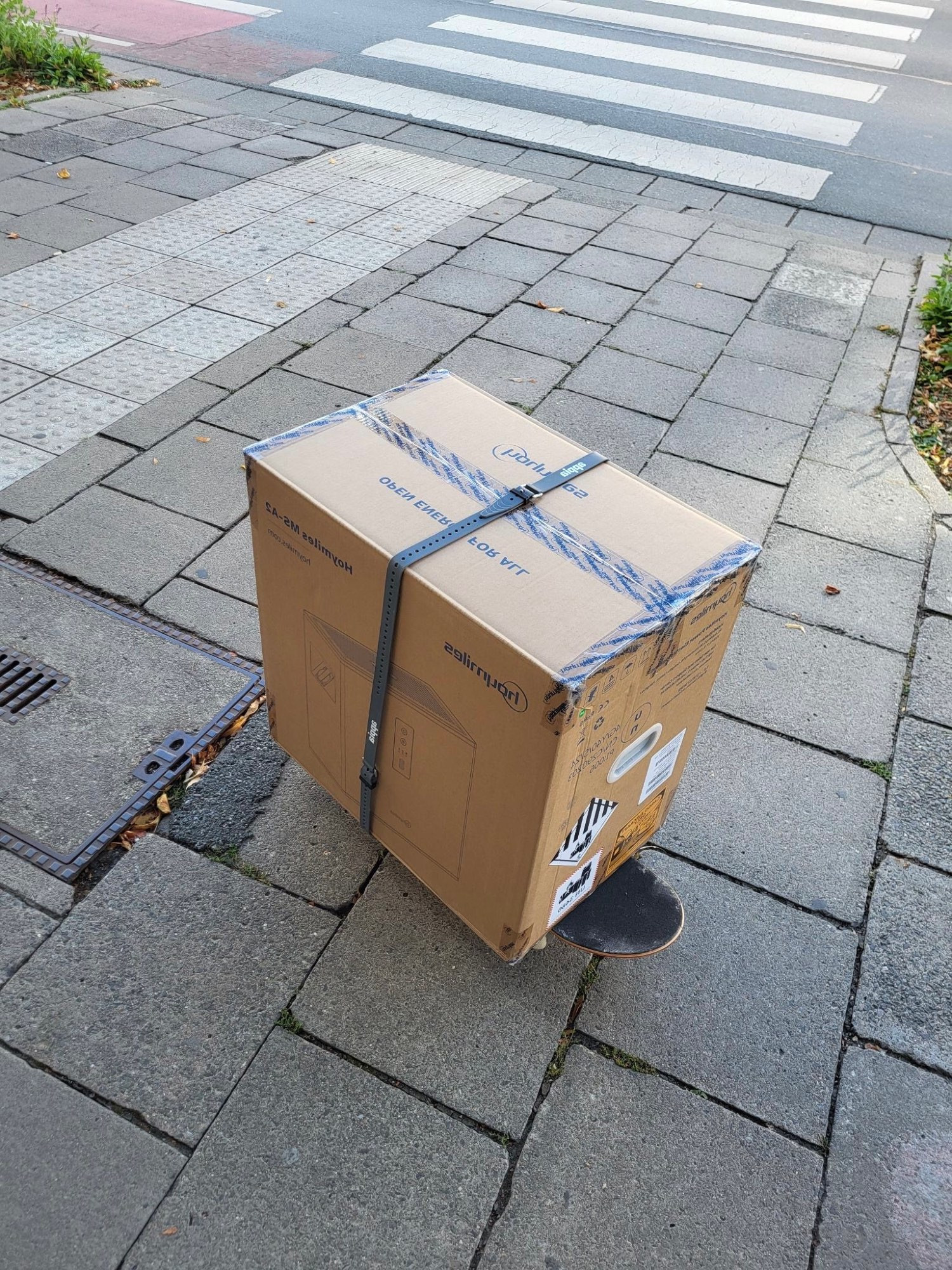 Auf dem Pflaster steht eine Kiste aufmeinem skateboard. 