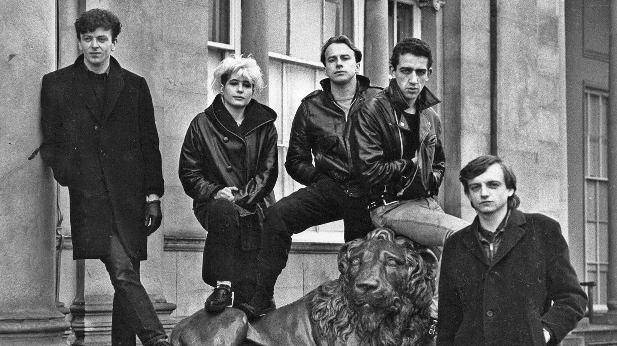 A b/w pic of the British band The Fall posing on the staircase in front of John Peel's studio, ca. 1980