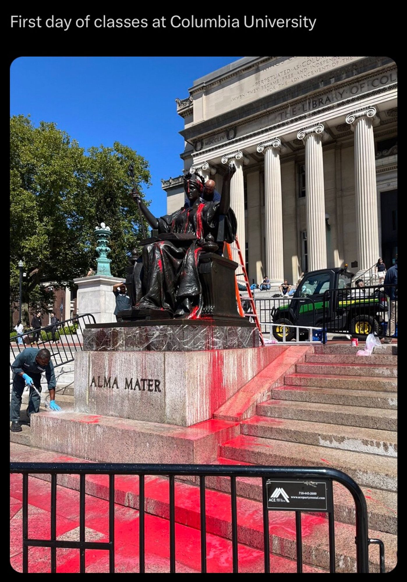 Screenshot of a tweet saying first day of classes at Columbia with the giant statue covered in red paint and someone trying to clean it