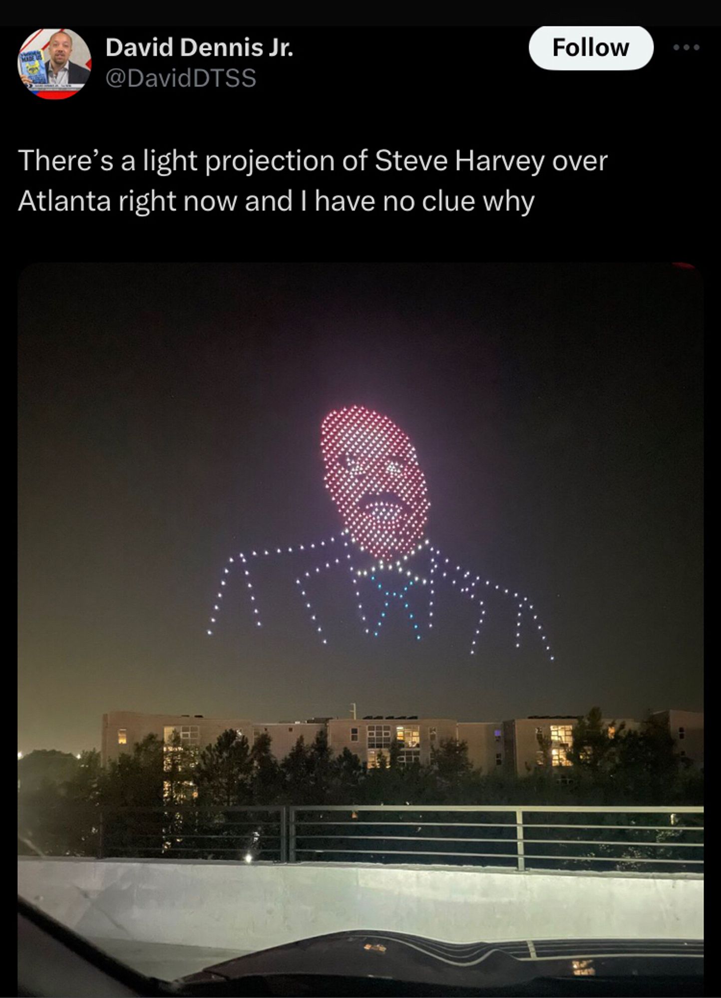 Tweet from davidDTSS with a photo of the described There’s a light projection of Steve Harvey over Atlanta right now and I have no clue why