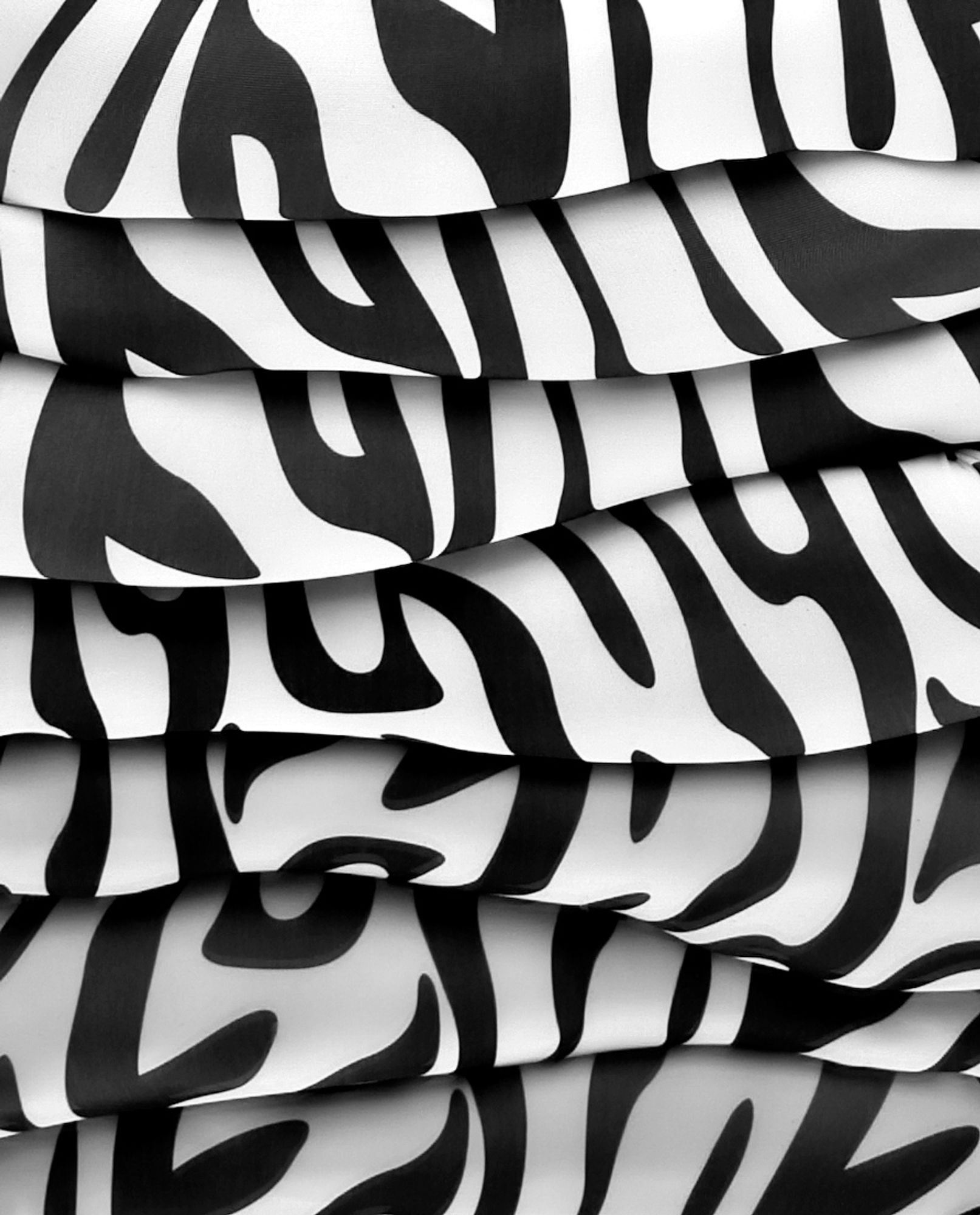 Close up black and white photo of arms and legs in zebra print zentai reflected in a mirror