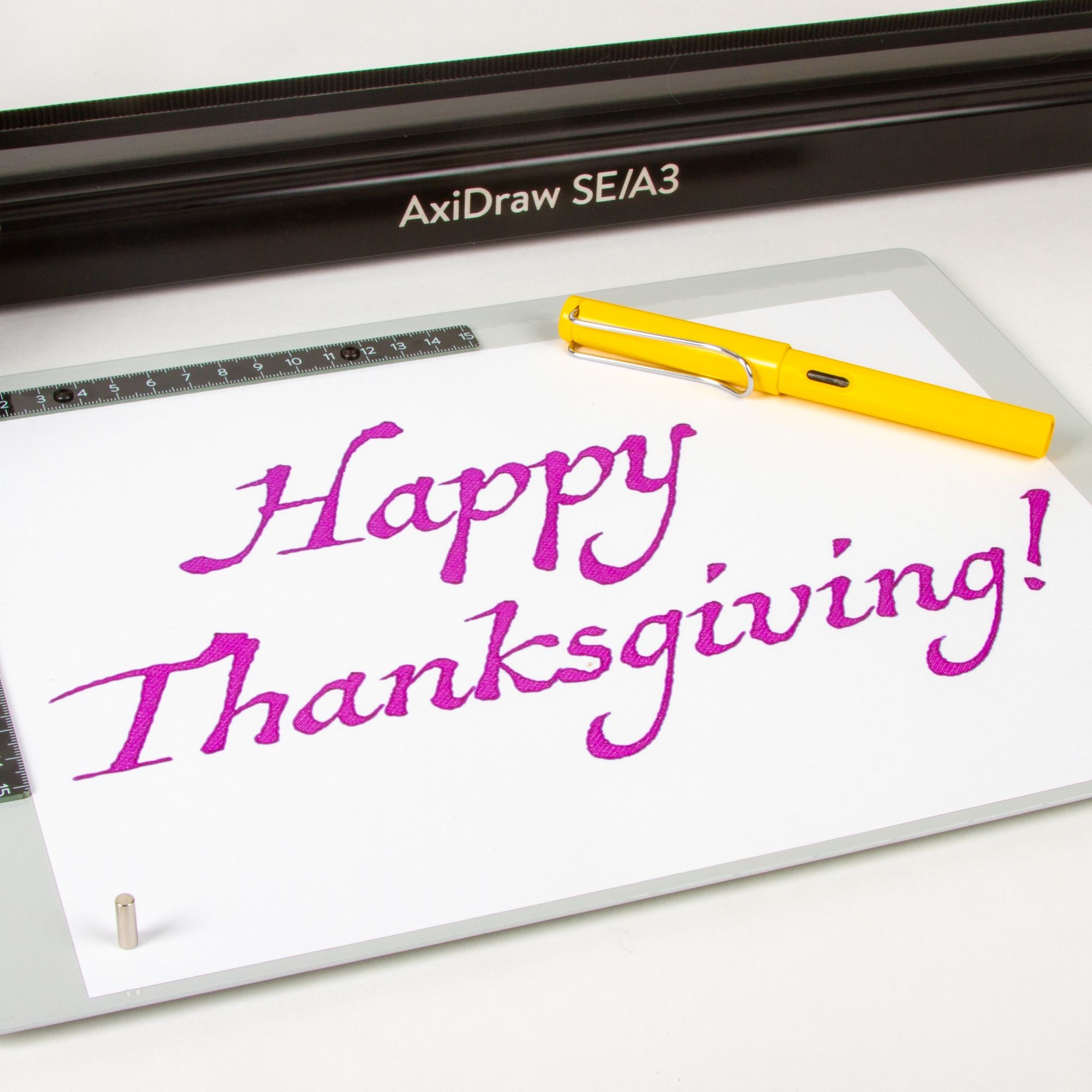 Happy Thanksgiving, as written out with a pen plotter (AxiDraw SE/A3) in purple ink