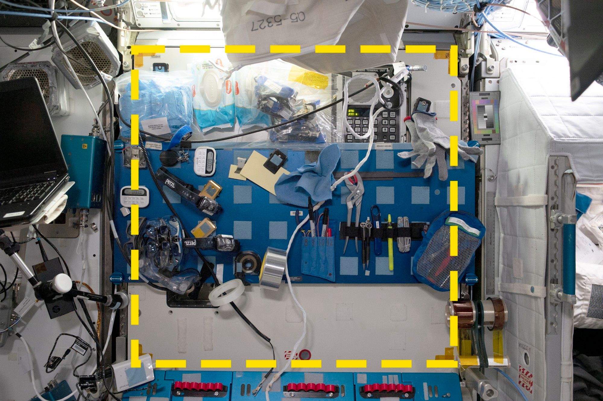 A photo of a workstation in the Node 2 module of the International Space Station. A yellow dotted line shows the boundaries of Square 03.