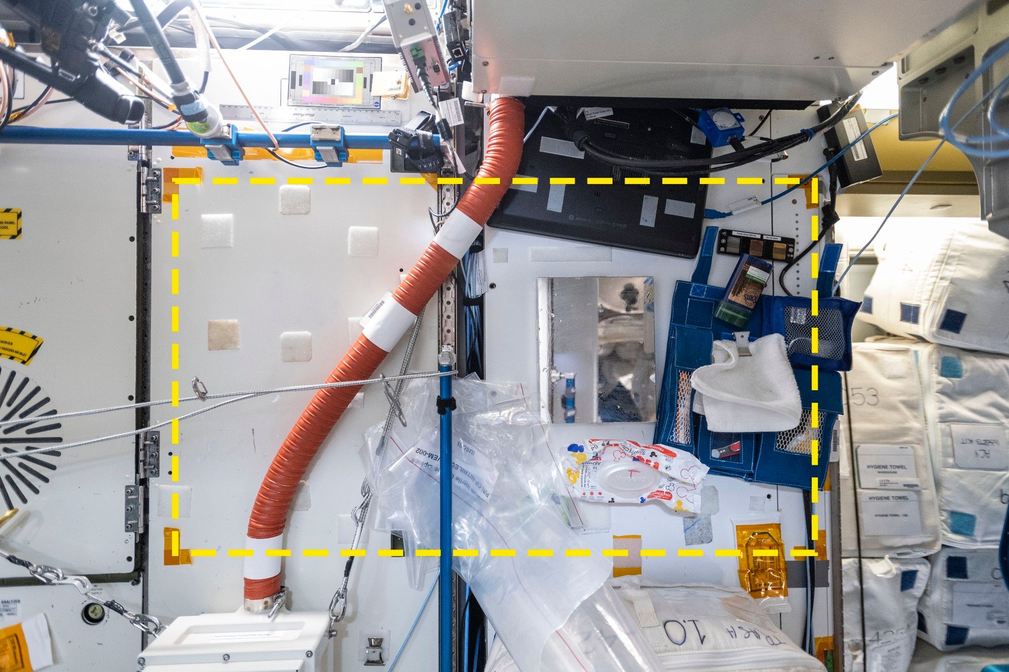 A photo of a wall in the Node 3 module of the International Space Station. A yellow dotted line shows the boundaries of Square 05.