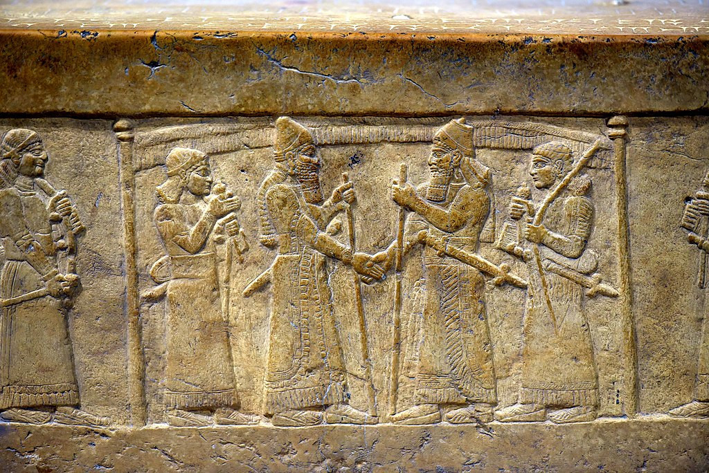 Stone relief of two Mesopotamian kings greeting each other. Ca 845 BCE. From the throne dais of Shalmaneser III at the Iraq Museum in Baghdad.