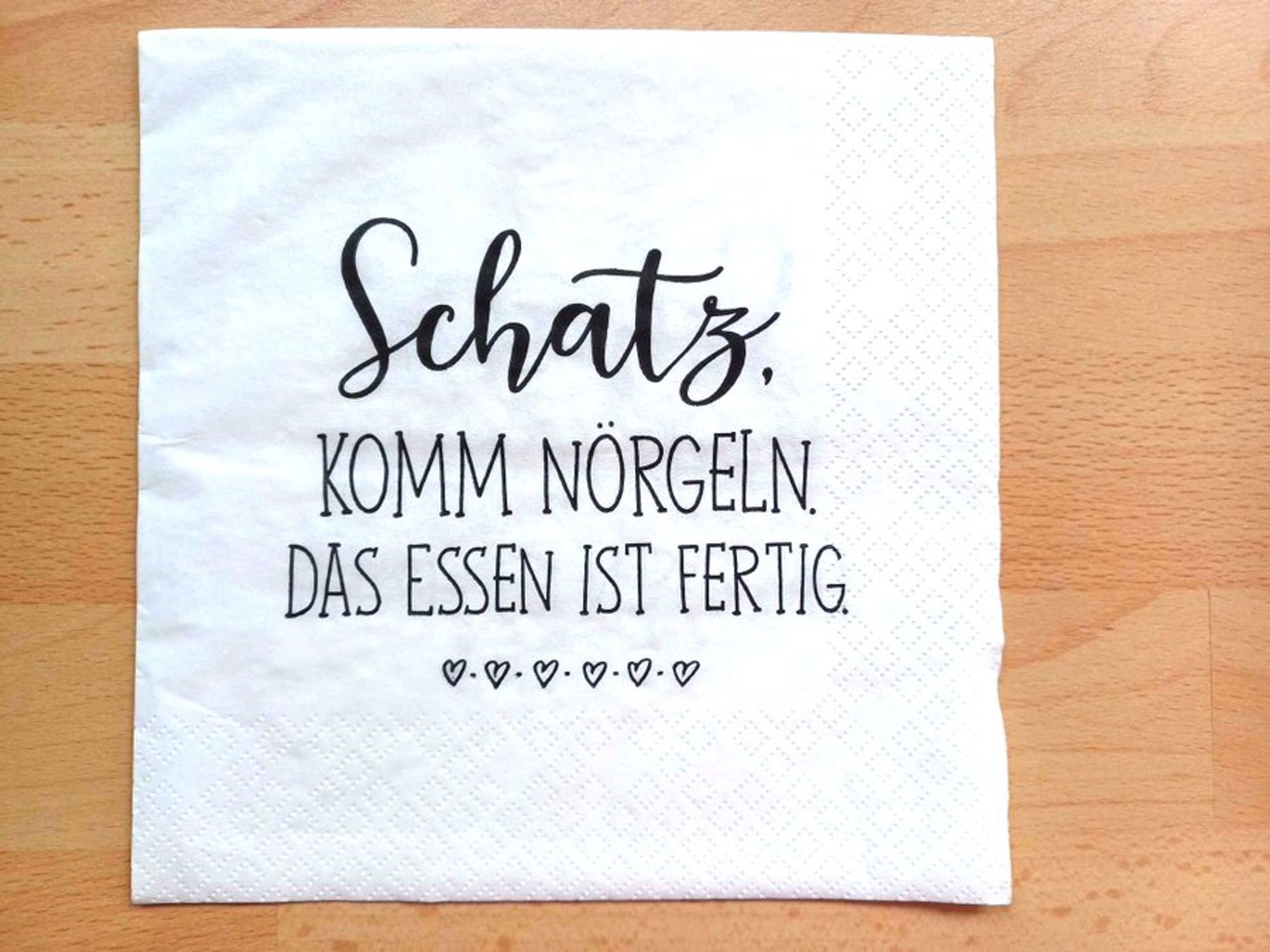 Eine Papierserviette mit dem Text:

Schatz, komm nörgeln. Das Essen ist fertig.