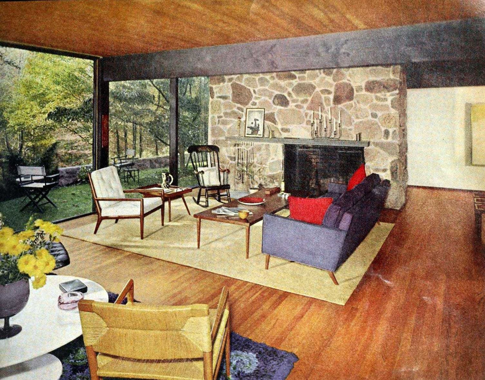 midcentury modernesque interior with warm wood, solid furniture, stone accents, sweeping views of the forest, large hallways