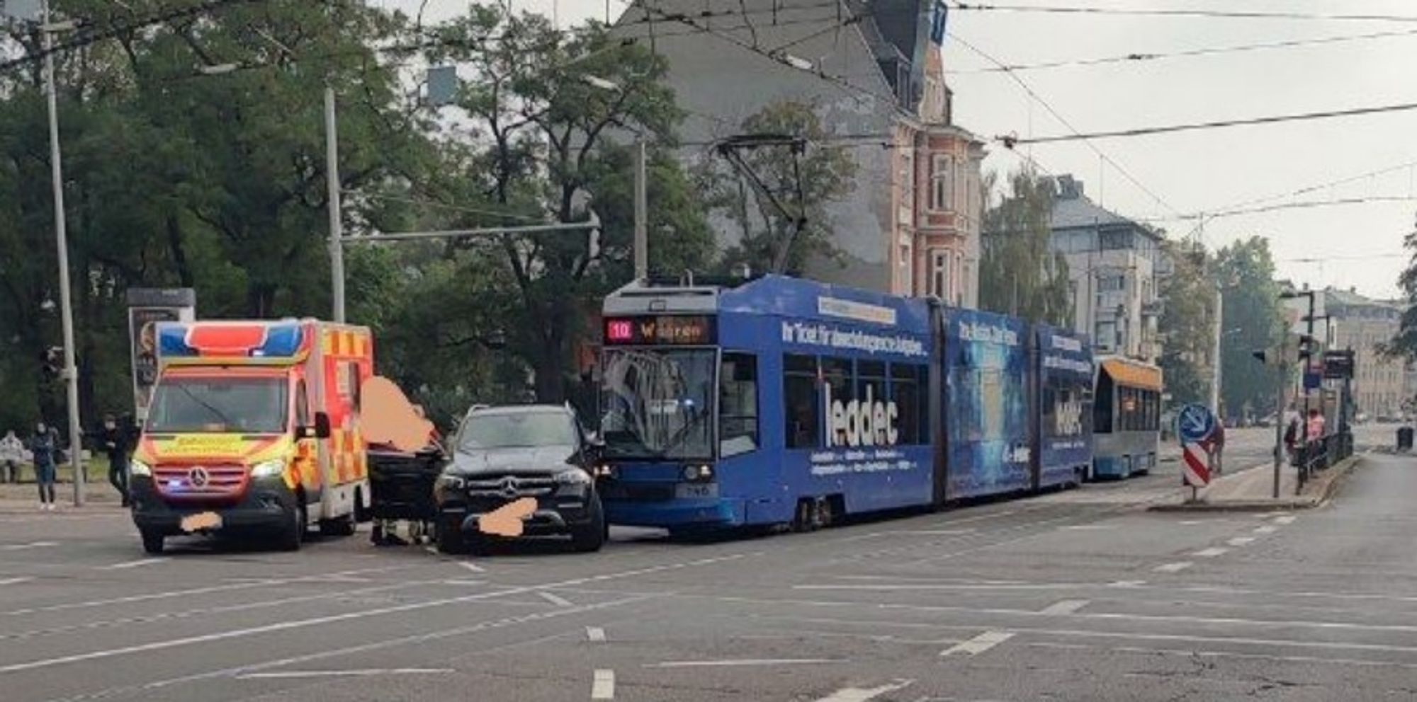 Ein von einer Straßenbahn angefahrener Mercedes-SUV steht neben einem Rettungswagen