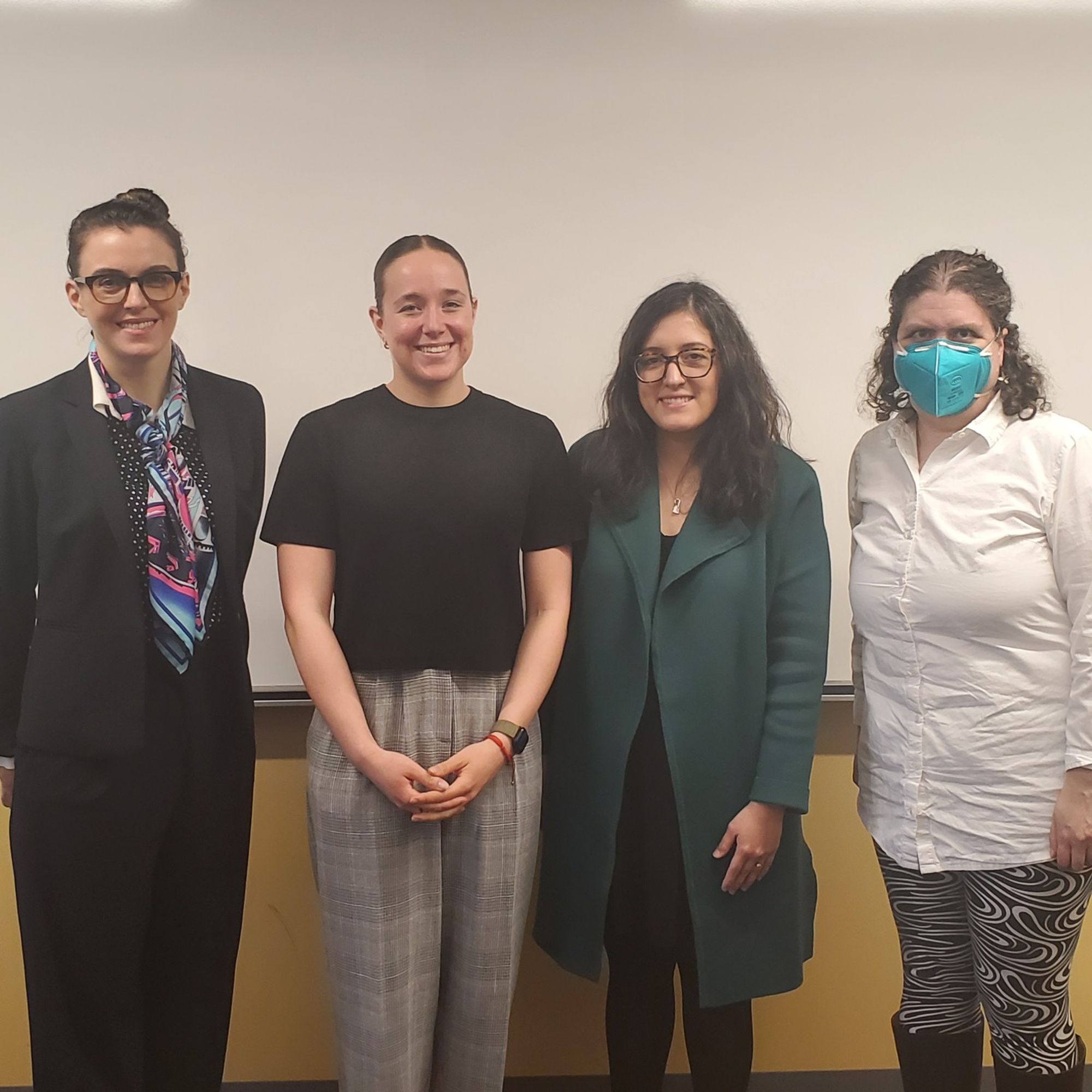 4 people smiling in celebration of student's thesis defense.