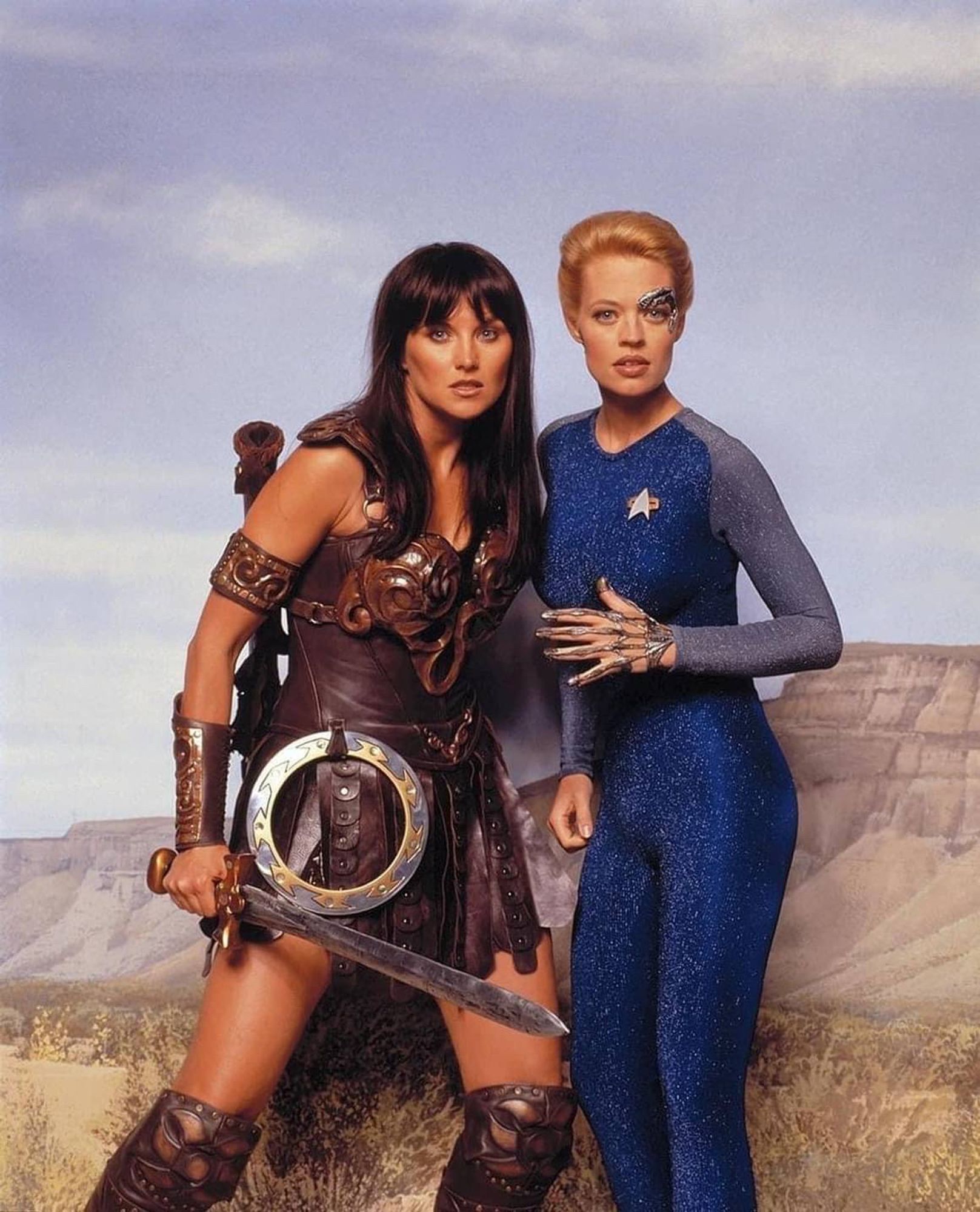 Photoshoot with Jeri Ryan and Lucy Lawless as Seven and Xenia, against a painted desert backdrop. 