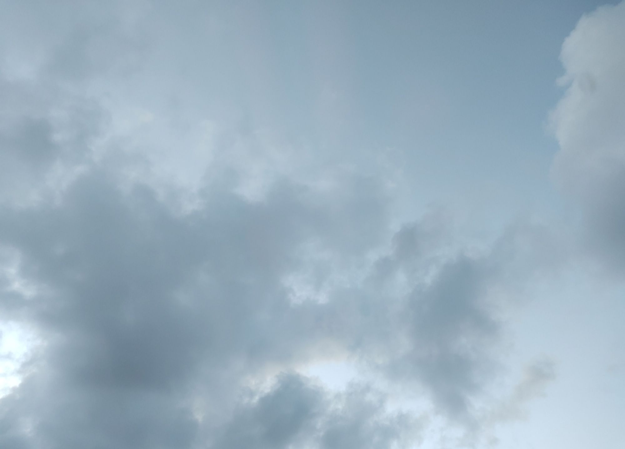 Ciel breton après une journée de pluie, toujours nuageux, avec du vent, peu avant le coucher du soleil.
On y voit des nuages gris et blancs nombreux mais peu épais, sur fond de ciel bleuté. Derrière on devine des lueurs de soleil couchant.