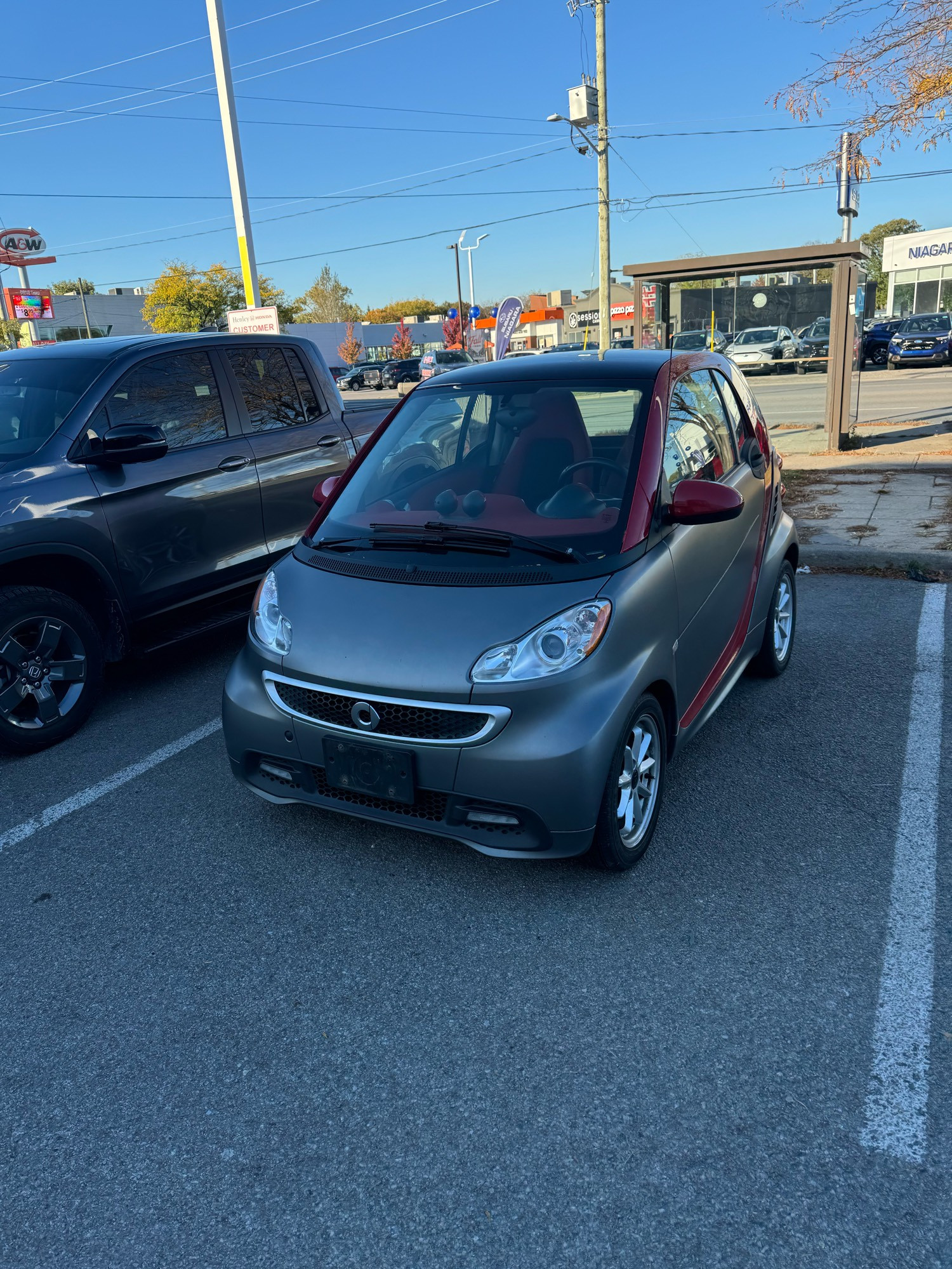 A sold smart car sits forlorn without its plates