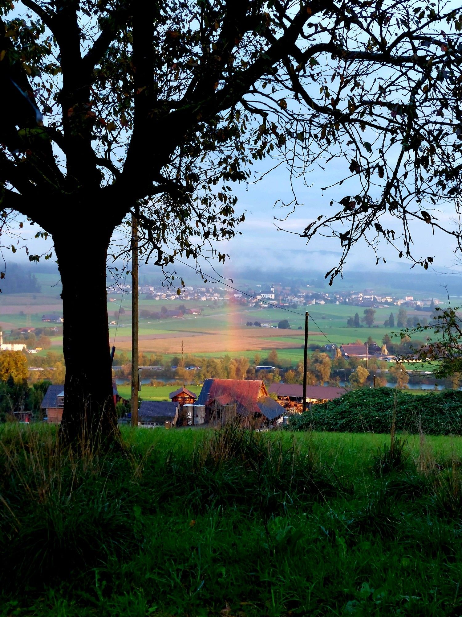 The start or end of a Rainbow above a farm.