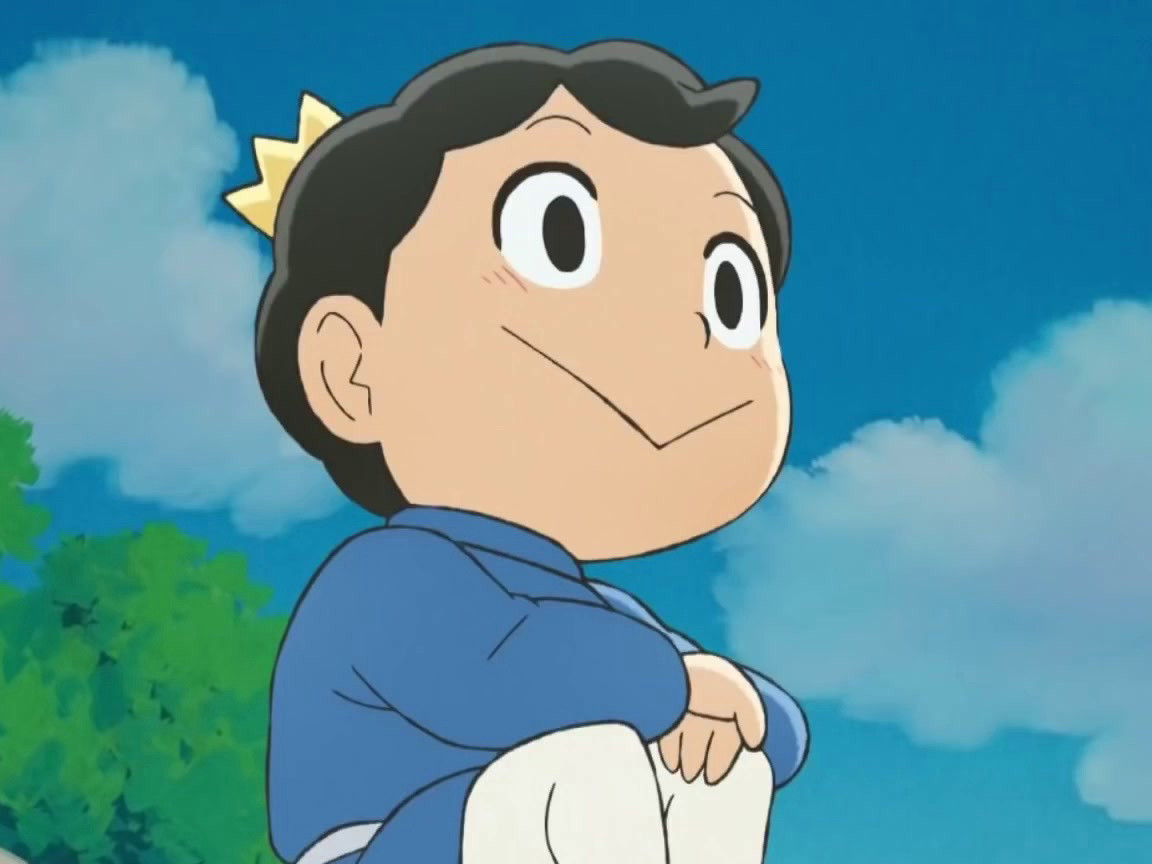 A screenshot from the anime "Ranking of Kings", portraying its protagonist Bojji as he sits on a wall looking off into the distance with his usual trademark smile.