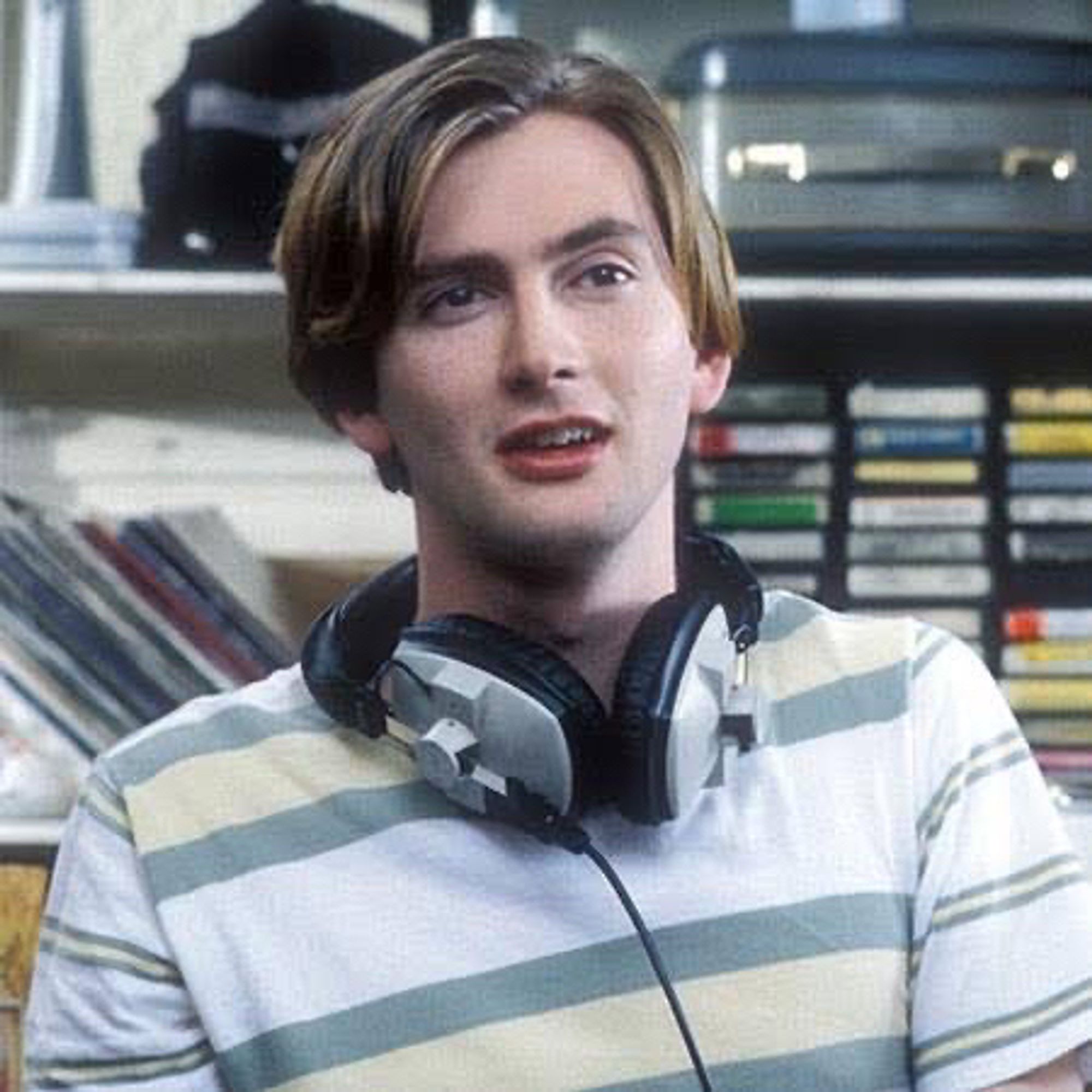 Young David Tennant as Campbell Bain. His hair is straight, brown and has blond lights. He has a headphone around his neck.