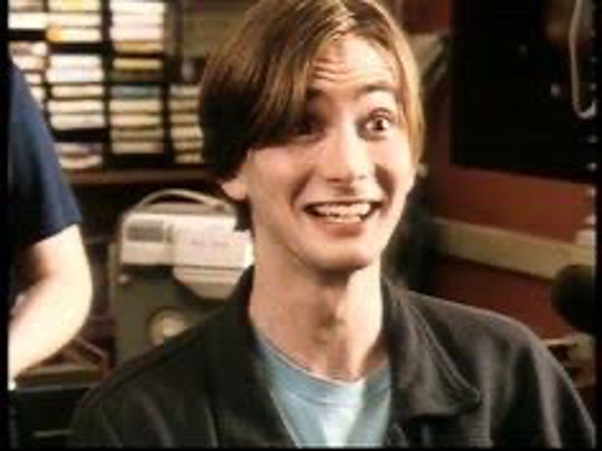 Young David Tennant as Campbell Bain. His hair is straight, brown and has blond lights. He smiling and his eyebrows are up curved.