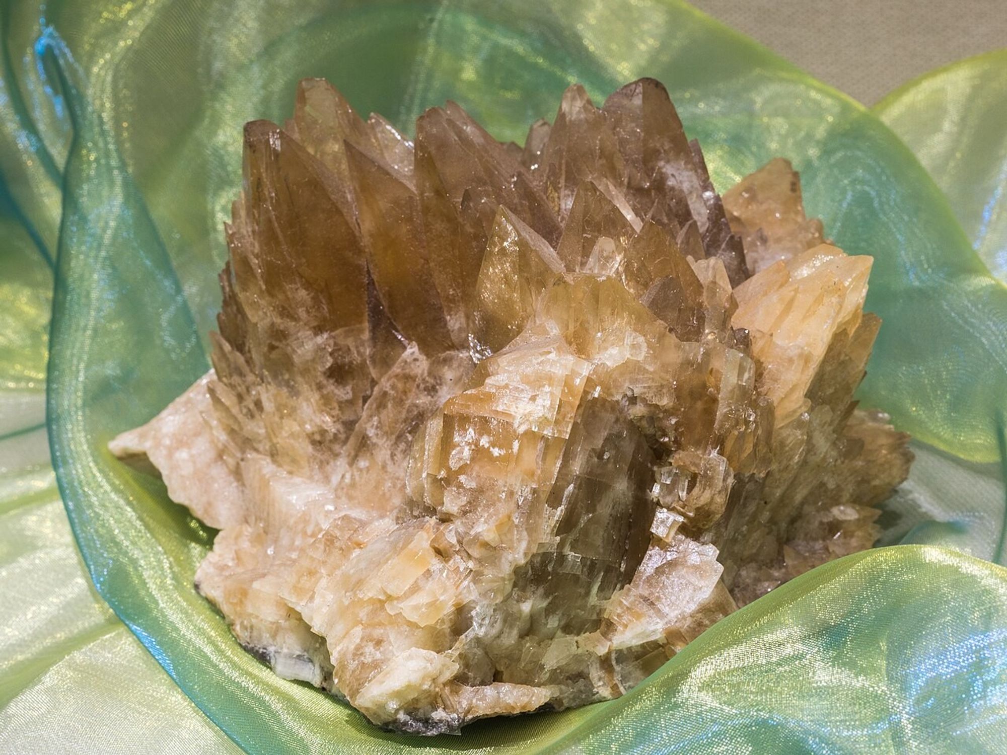 A large brown chunk of calcite, nestled all cozy in a soft green fabric.

© Raimond Spekking / CC BY-SA 4.0 (via Wikimedia Commons)