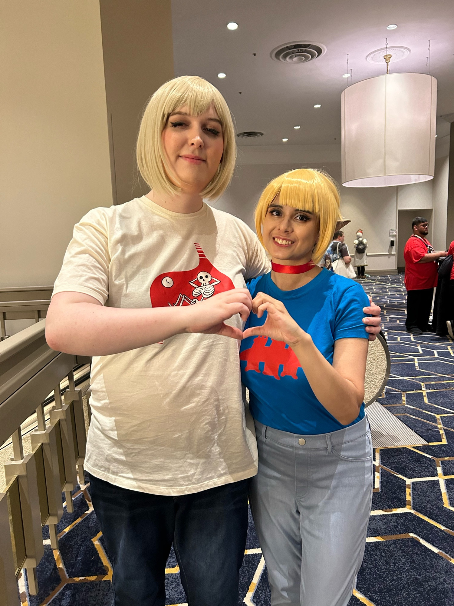 my wife and i, in Farcille cosplay, doing the heart hands meme with our other arms around each other.