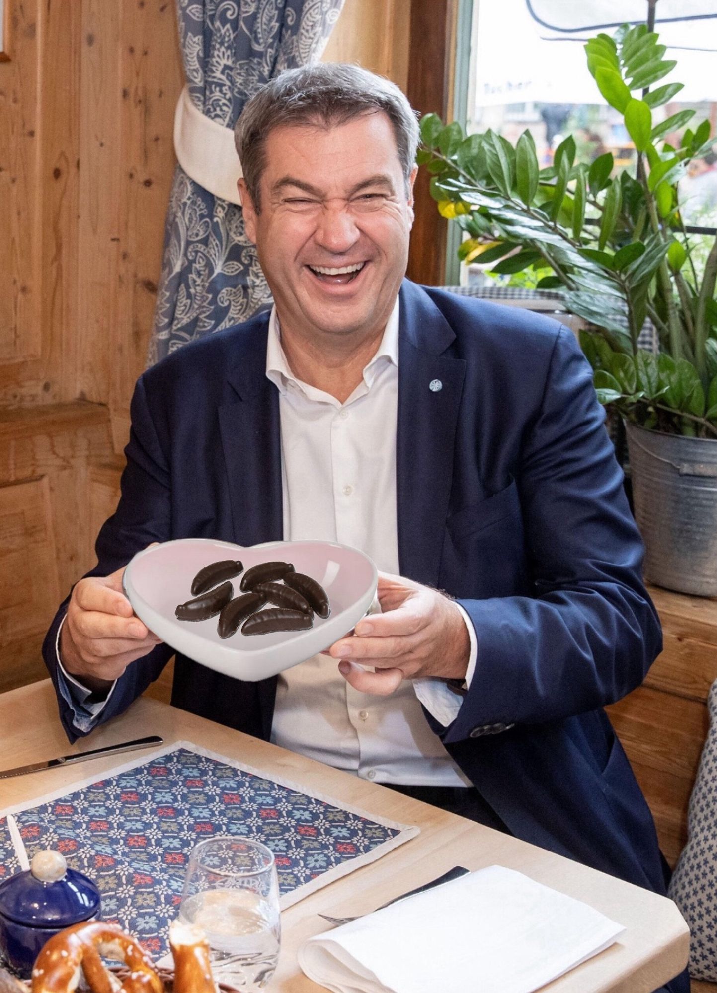 Söder grinsend mit einem herzförmigen Teller in der Hand, darauf liegen Gelee Bananen