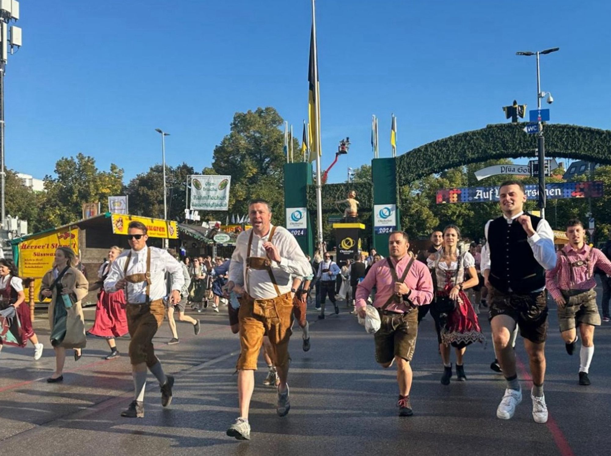 Wiesnbesucher in Tracht rennen irgendwo hin