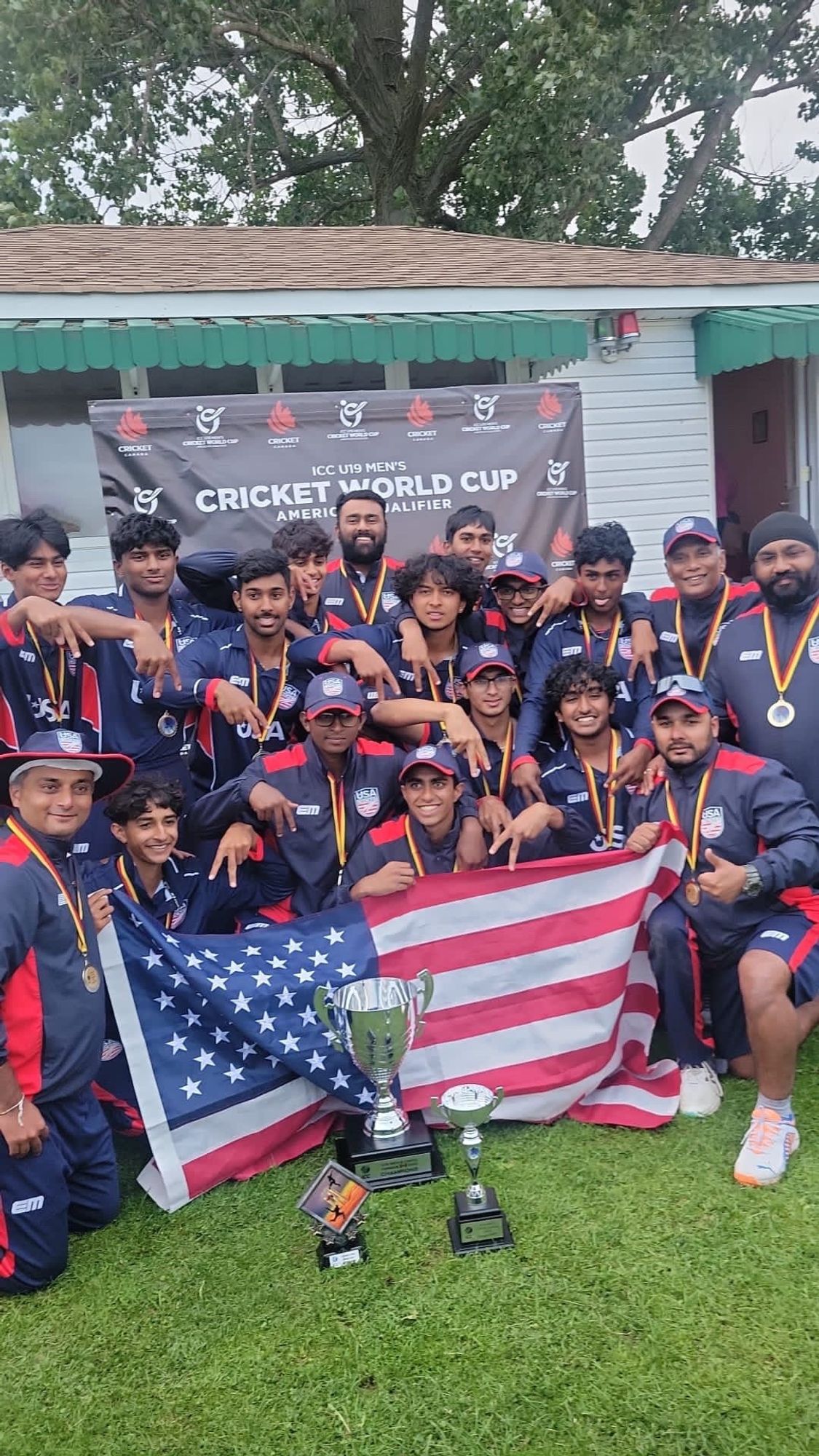 Here they are posing in front of the US flag and the Americas qualifier trophy.