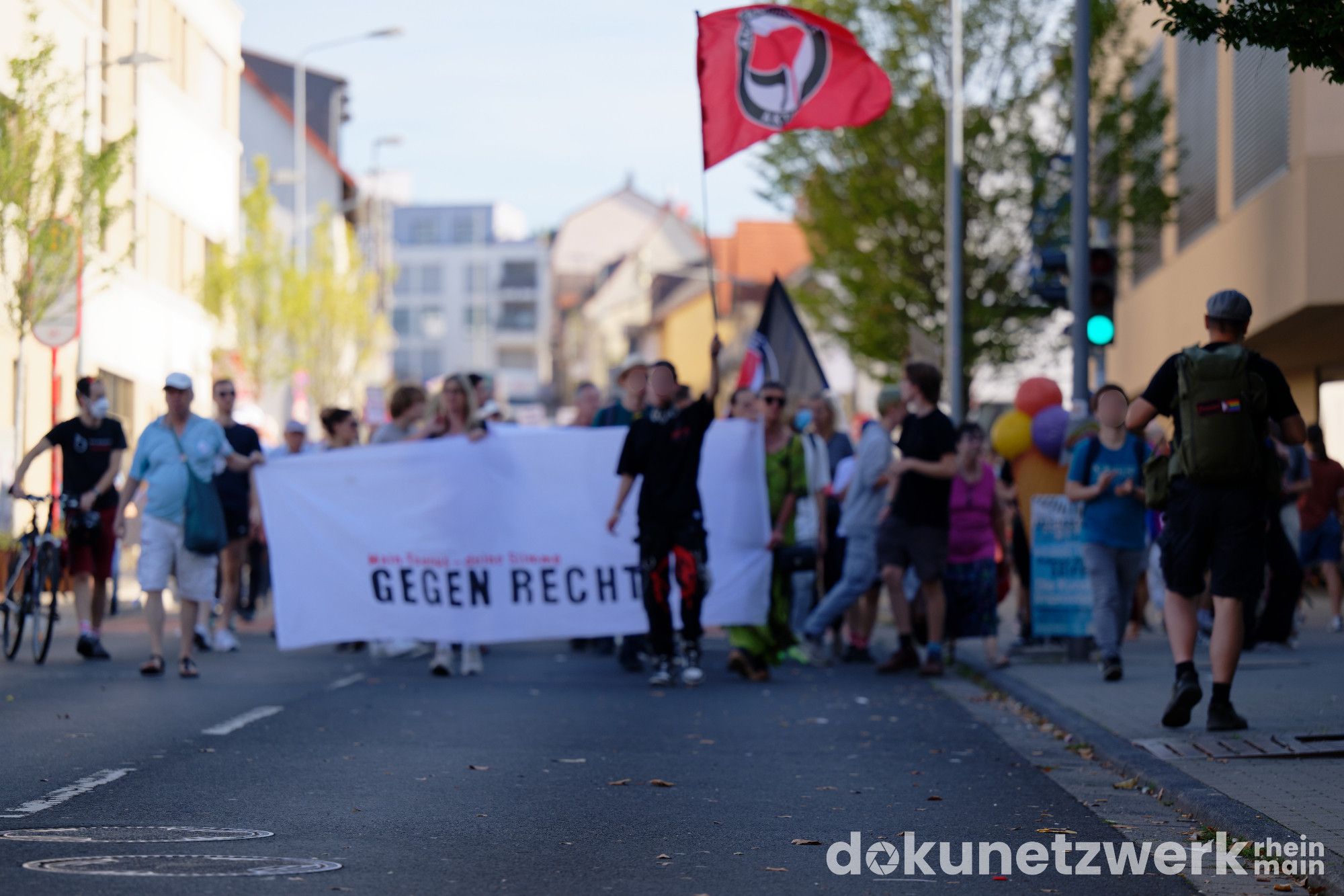 Der Anfang der Demo. Auf dem weißen Transparent steht Gegen Rechte. Davor läuft eine Person und hält eine Antifa-Flagge in der Höhe