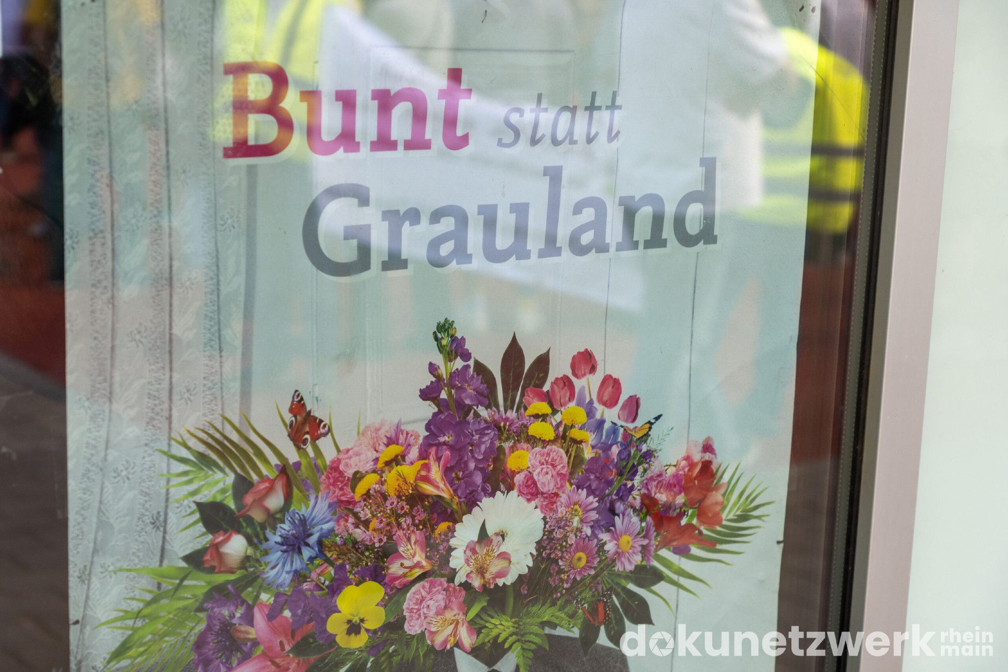 Ein Schild hinter einer Glasscheibe worauf steht: Bunt statt Gauland